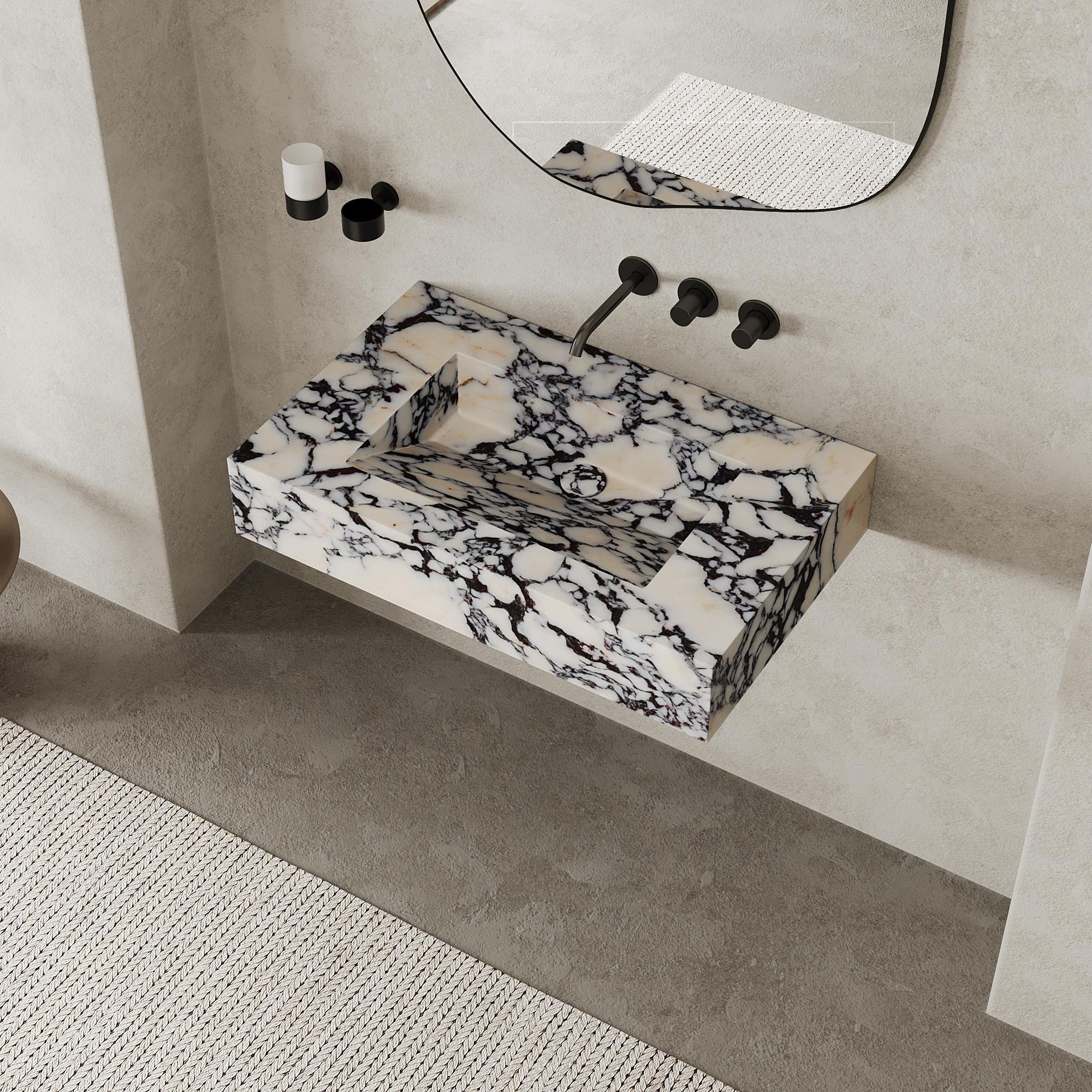 Eleva tu espacio de baño con nuestro lavabo rectangular de mármol Skadi, una fusión perfecta de diseño minimalista y elegancia natural. Su superficie lisa y pulida resalta el veteado y la textura únicos del mármol, ideal para baños modernos que