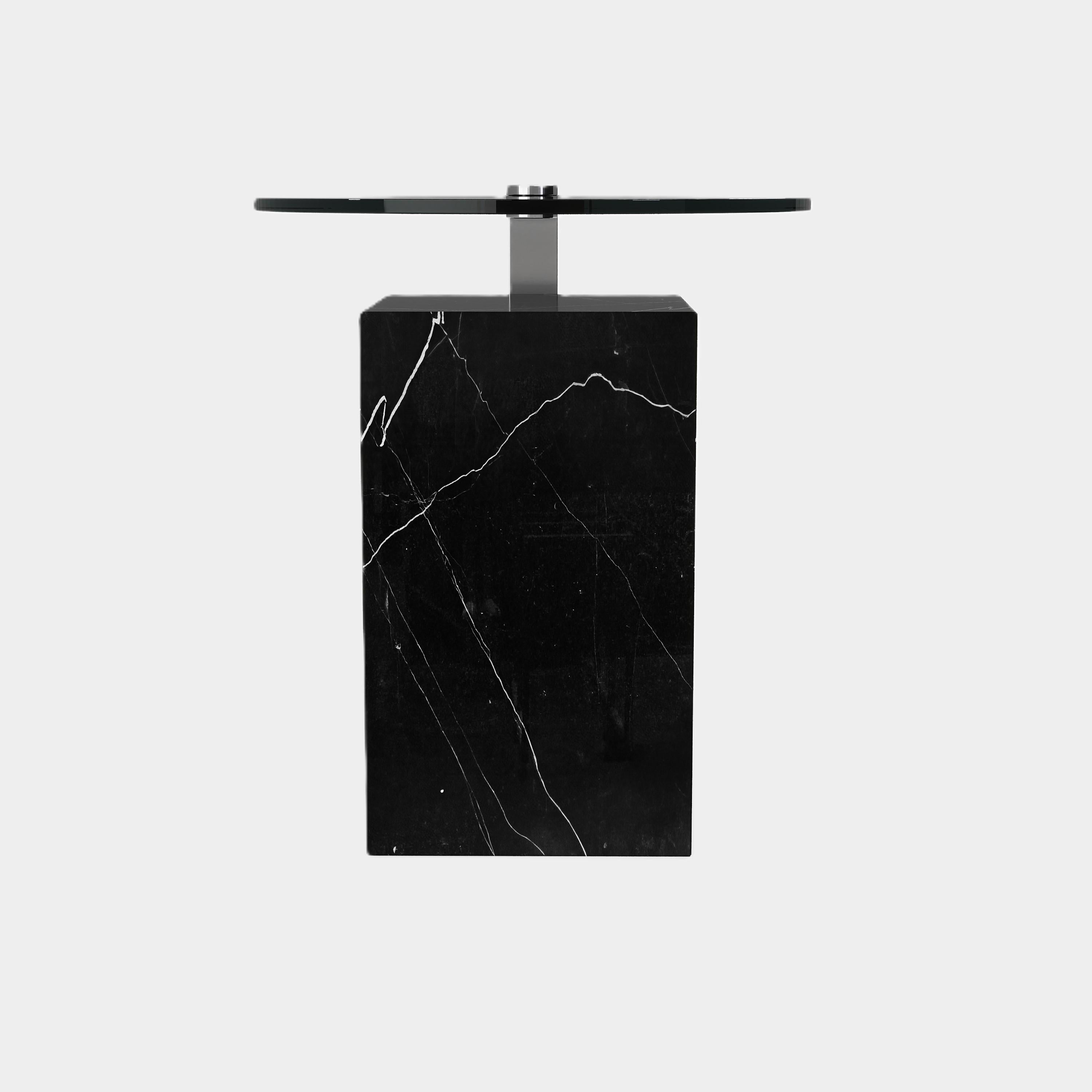 Cette table d'appoint est composée d'une base rectangulaire en marbre avec des veines naturelles uniques, surmontée d'une surface métallique élégante. Sa silhouette moderne et ses matériaux contrastés créent un point focal saisissant pour votre