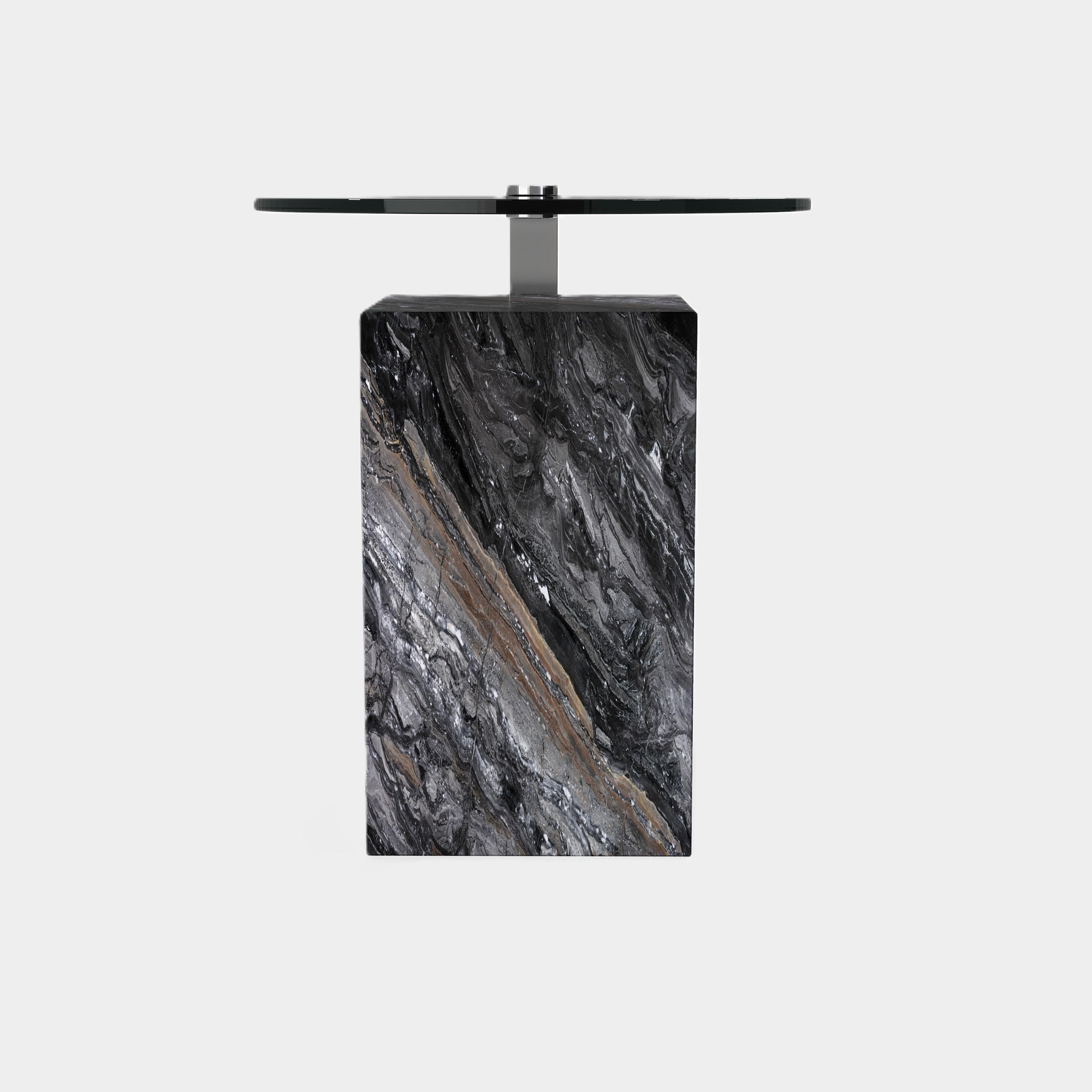 Cette table d'appoint est composée d'une base rectangulaire en marbre avec des veines naturelles uniques, surmontée d'une surface métallique élégante. Sa silhouette moderne et ses matériaux contrastés créent un point focal saisissant pour votre
