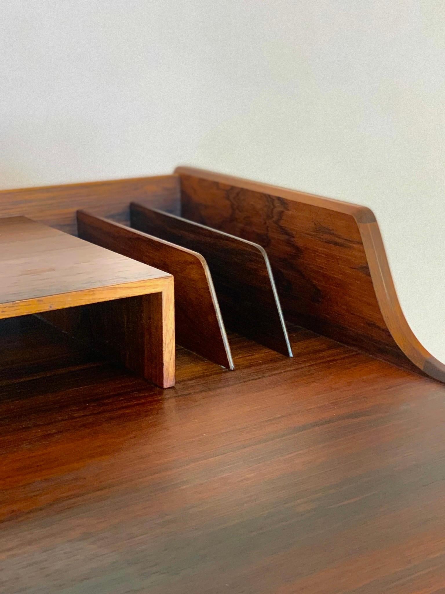 A rare desk designed by Arne Wahl Iversen. Made in Denmark during the 1950s. It features an organic shape with a wide table top with raised edges.  In the front side two generous drawers offers plenty of storage space. It can be elegantly used as a