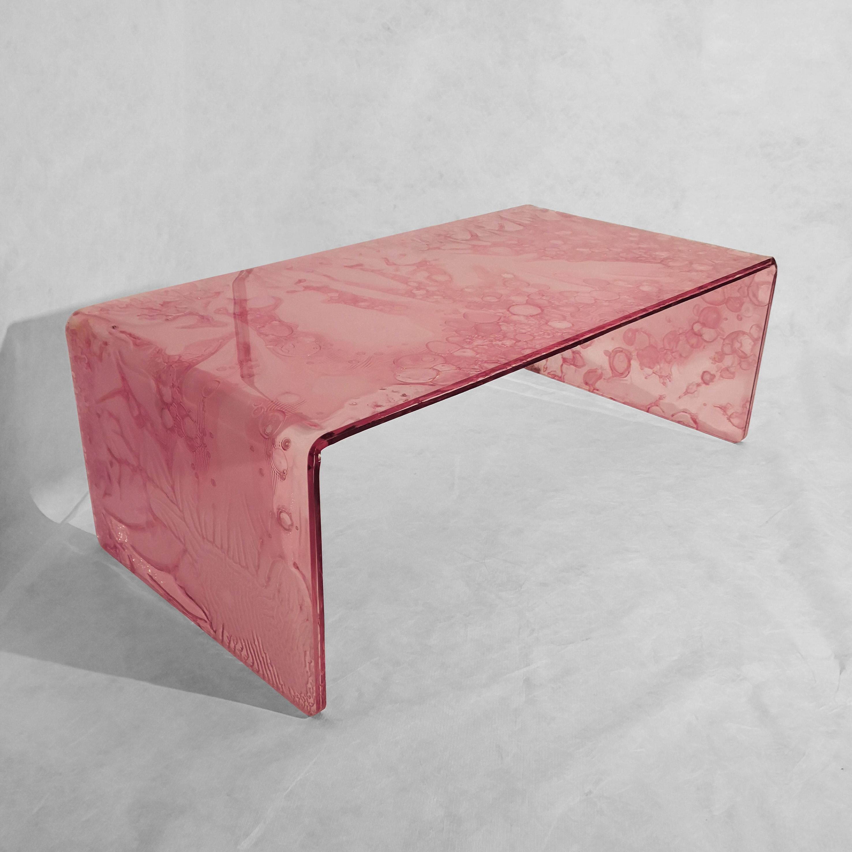 Table basse, fabriquée à la main en acrylique rose transparent coloré avec une technologie innovante.
Le matériau est fabriqué par la fusion de trois plaques, dont l'une d'entre elles
centre partiellement guéri.
Ce procédé crée des effets uniques