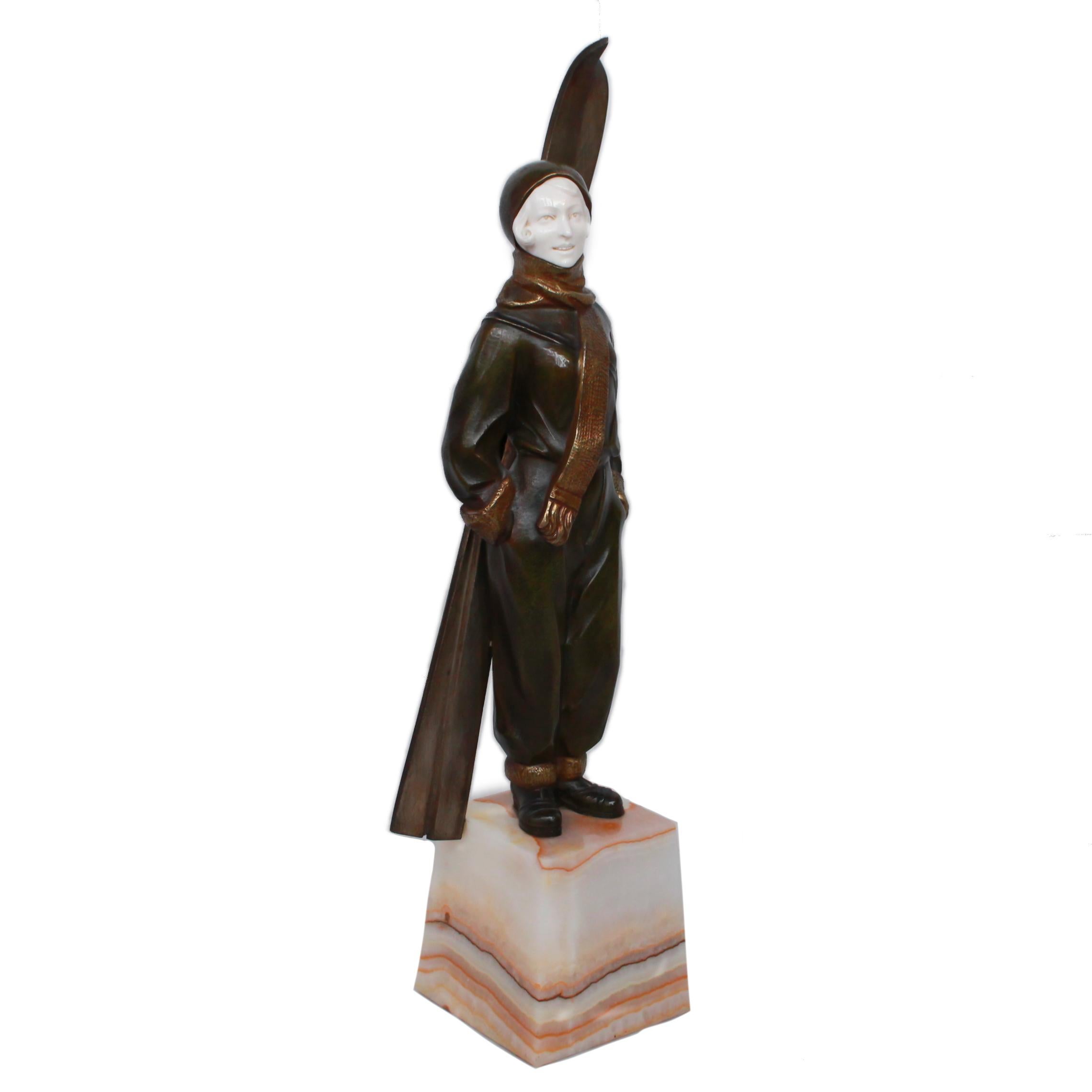 A patinated and gilt bronze and ivory figure of a lady skier. Cast and carved from a model as a young woman dressed for a day on the slopes with her skis strapped to her back. Raised on an onyx plinth.

Engraved 'L.Sosson' to base.

Artist: