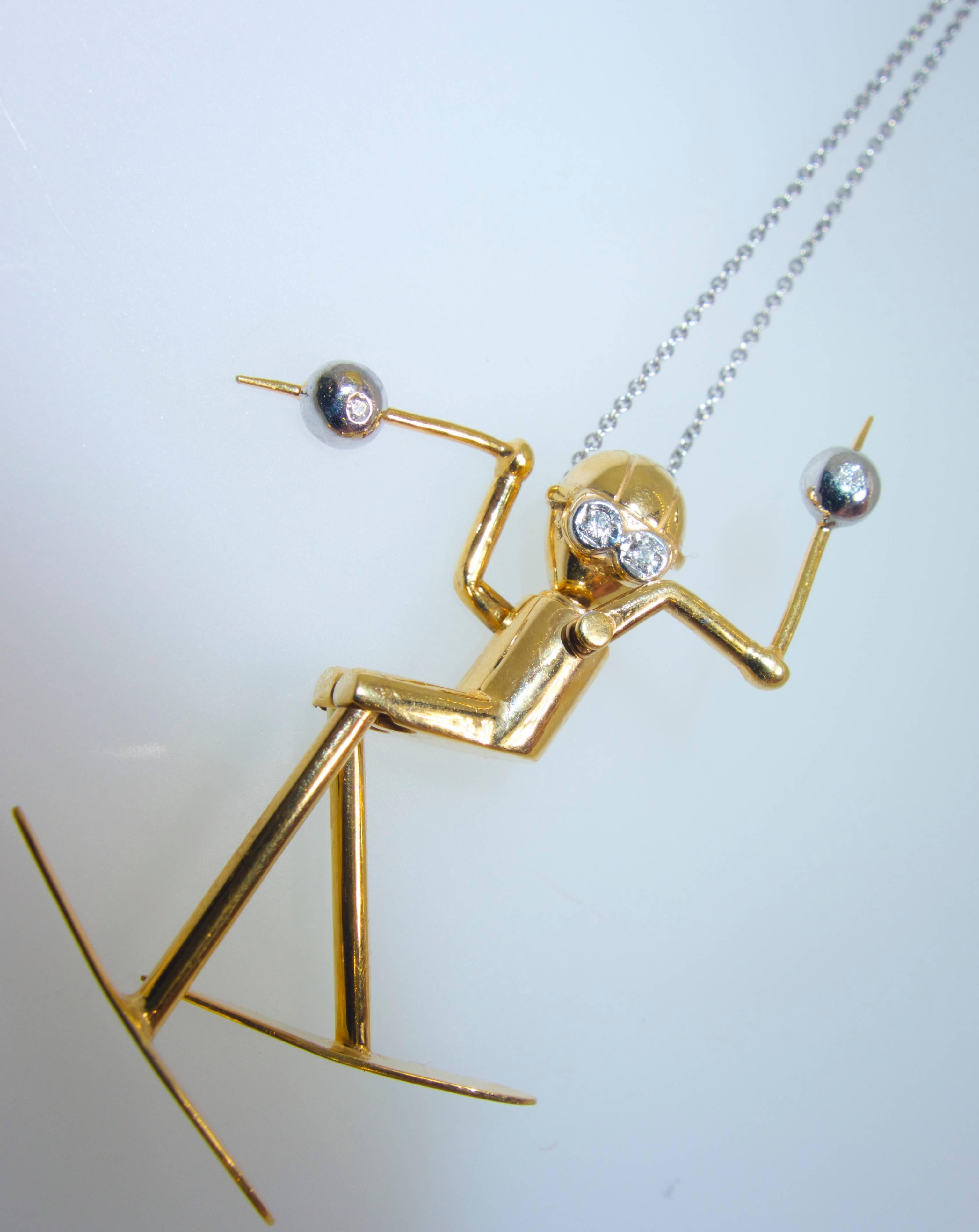 Skier hand made, all articulated so the joints move, this happy skier is in gold with accents of round white brilliant cut diamonds, 4 .  It is 1.5 inches long and marked 585 for 14K and with the maker's initials JJ.