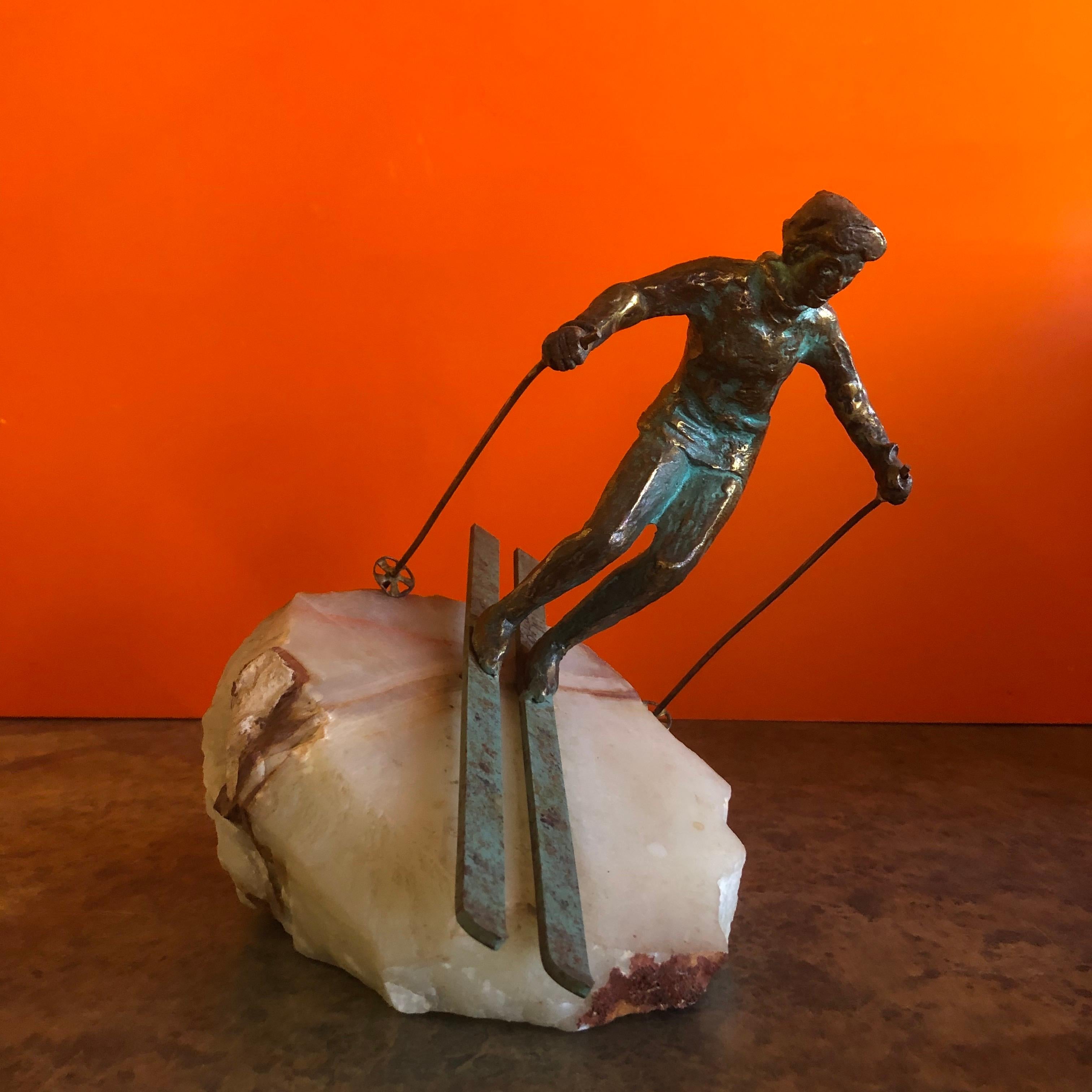 A very cool bronze downhill skier sculpture on a solid block of white onyx by C. Jere, circa 1971. The piece is signed 