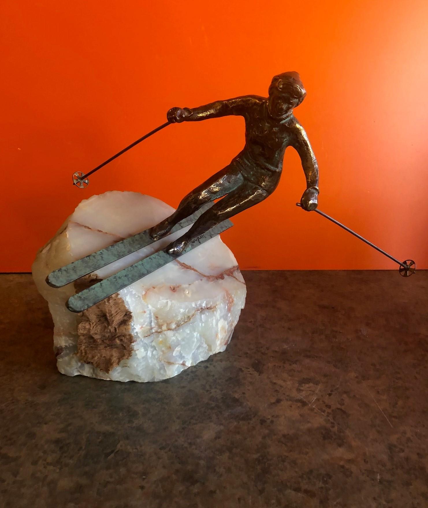 A very cool bronze downhill skier sculpture on a solid block of white onyx by C. Jere, circa 1970s. The piece is signed 