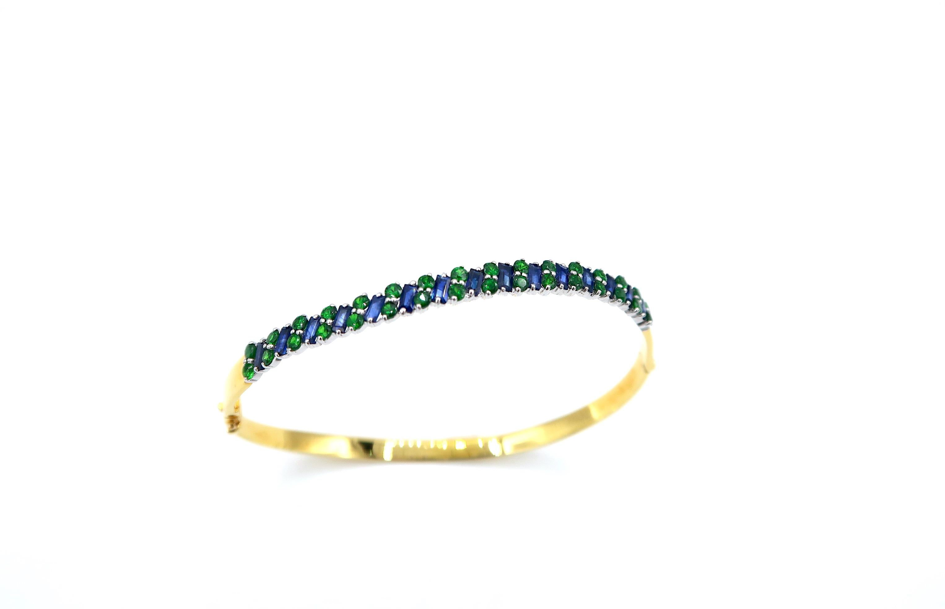Skinny Blue Sapphire Green Tsavorite Clamper Bangle in 18 Karat Yellow Gold and White Gold

Gold: 18K 14.08g.
Sapphire: 2.29cts.
Tsavorite: 1.47ct.