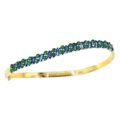 Armreif mit Klappverschluss aus 18 Karat Gold mit glänzendem blauem Saphir und grünem Tsavorit