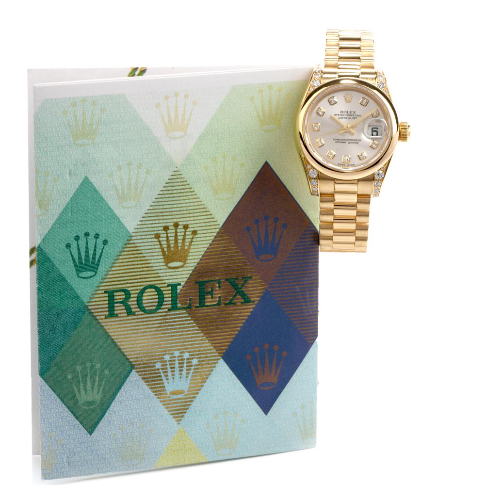 This Rolex President 26mm ladies DATEJUST watch REF #2038883 was cast in 98.6 grams of 18K yellow gold. It features a smooth bezel with diamond lugs, a silver diamond dial, gold hands and

a cyclops window at 3:00 with the date. This watch has a