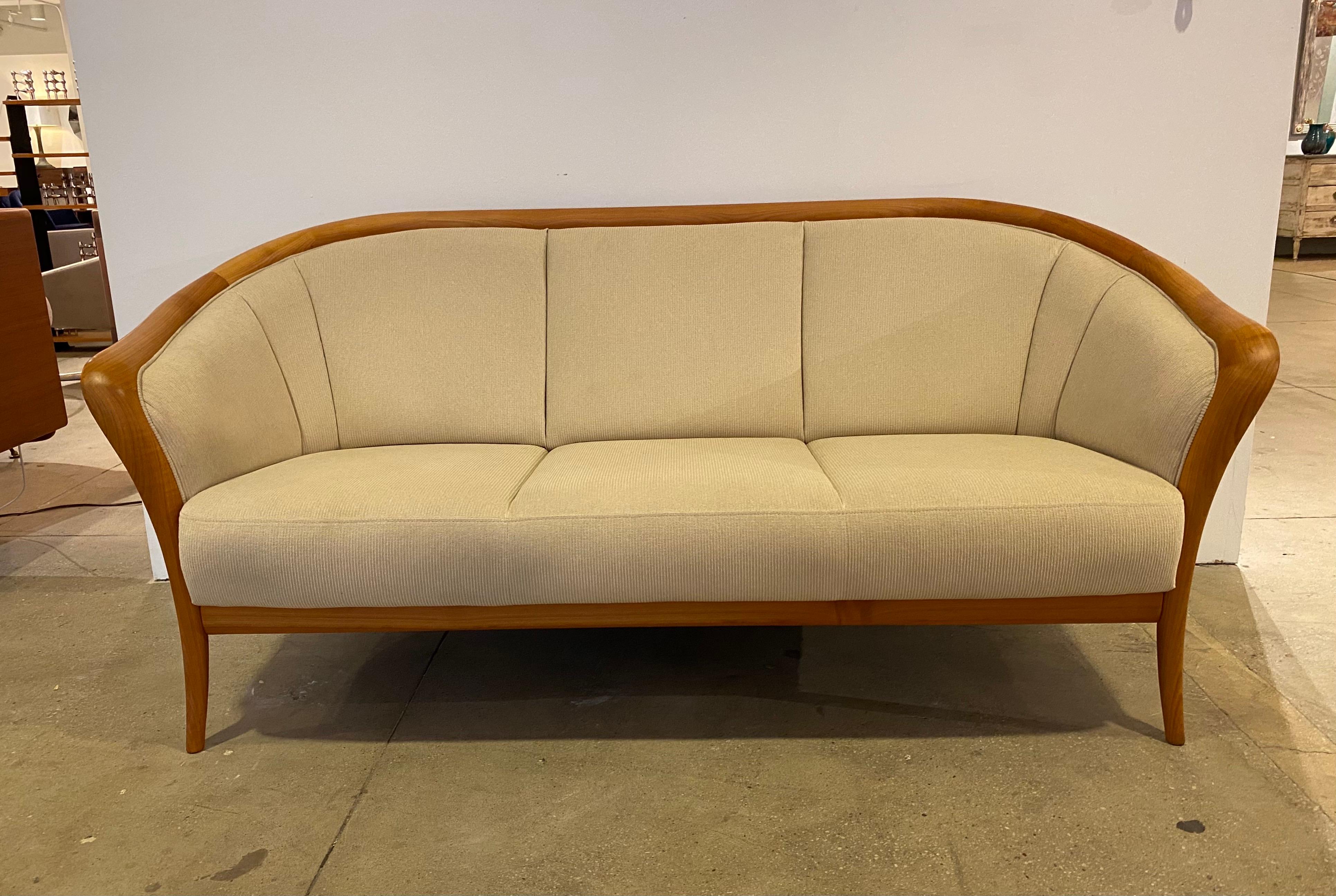 A timeless beautiful Danish sofa with swooping bent maple wood and cream upholstery. Can be used with many different styles. Made by the Danish maker, Skipper Mobler. Original label, 1970.