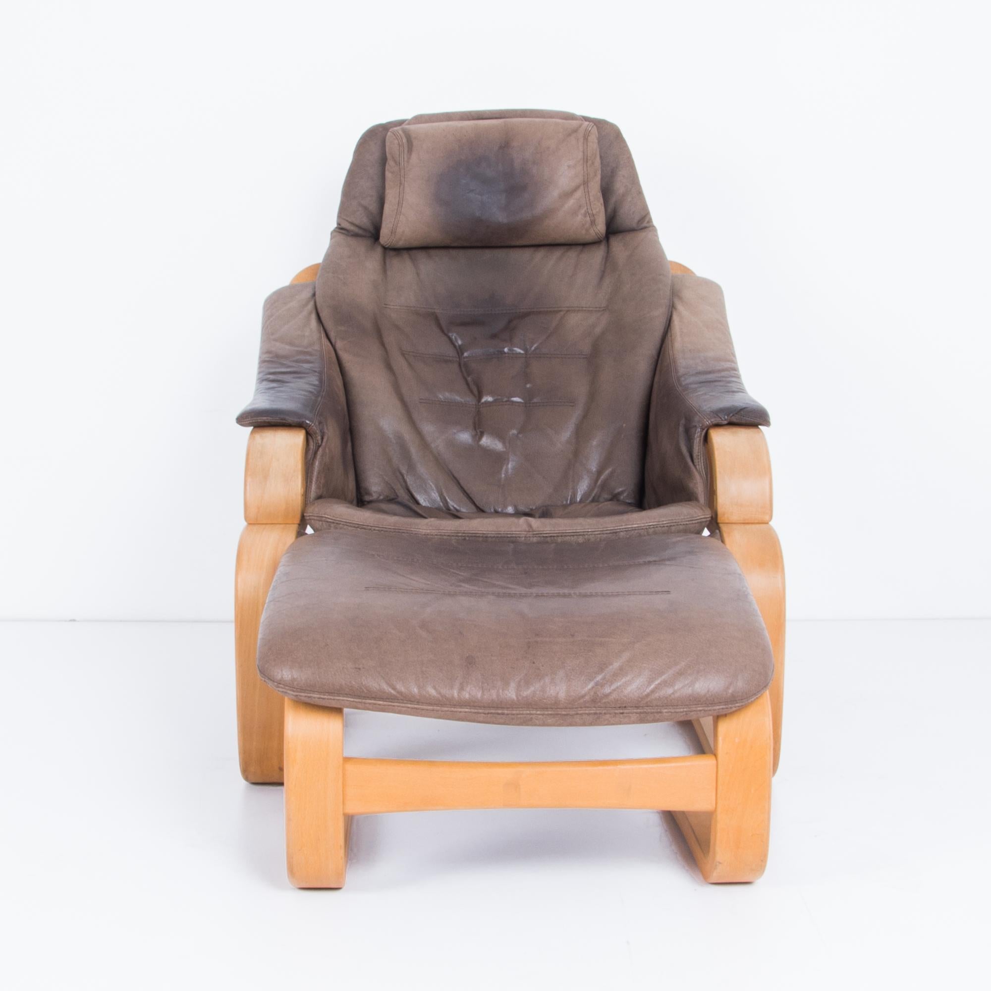 This original leather armchair and footrest by Danish manufacturer Skipper Mobler was made in the 1980s. A cantilevered bentwood frame references Scandinavian Modernism, while the gentle gradient of the grey leather softens the bright tones of the