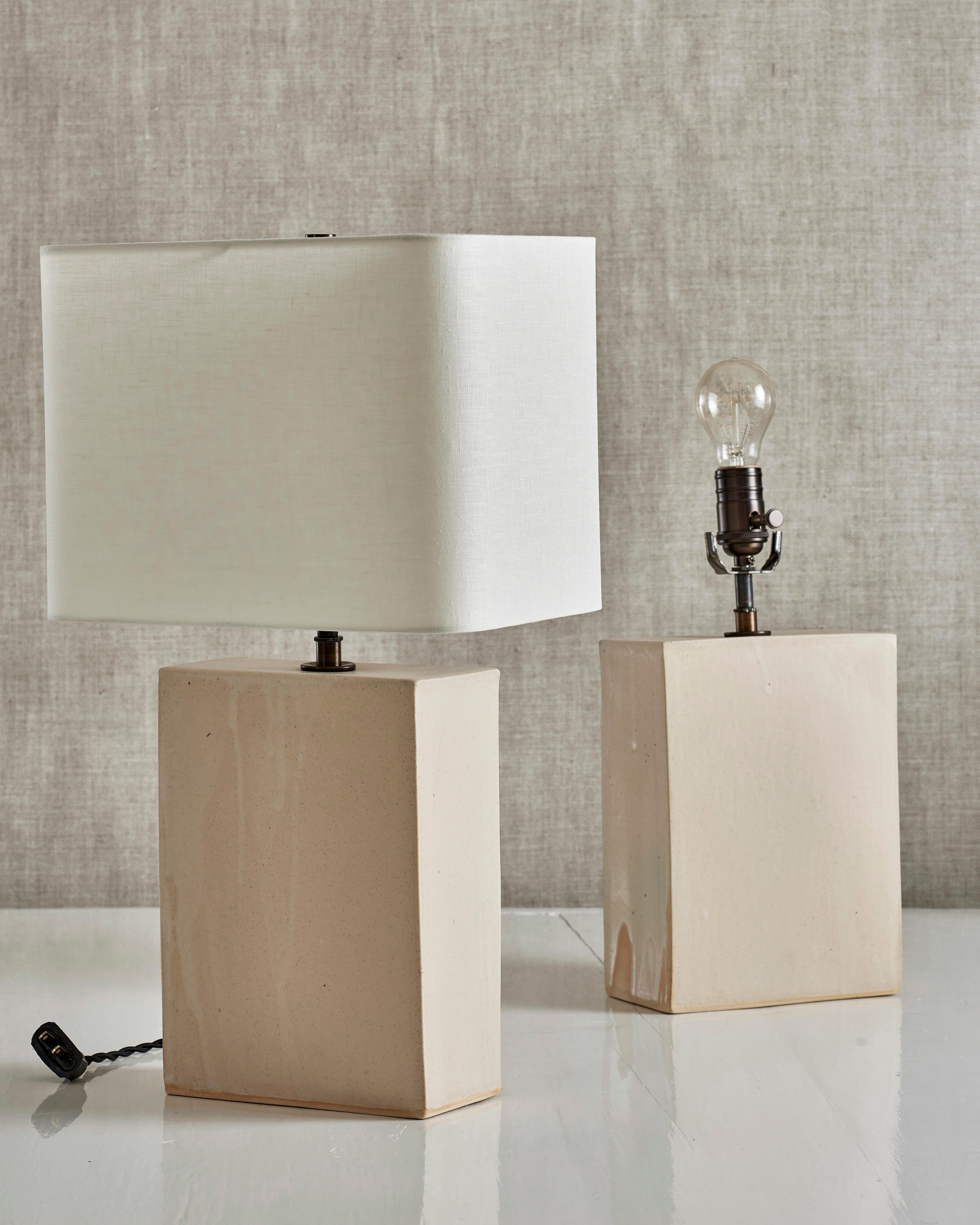 Handmade stoneware slab construction. Lamps are individually crafted and one of a kind.

Matte clear glaze over white stoneware. Antique brass fittings with braided black silk cord and off-white linen shade.

Measures: Box height 10.5”
Box