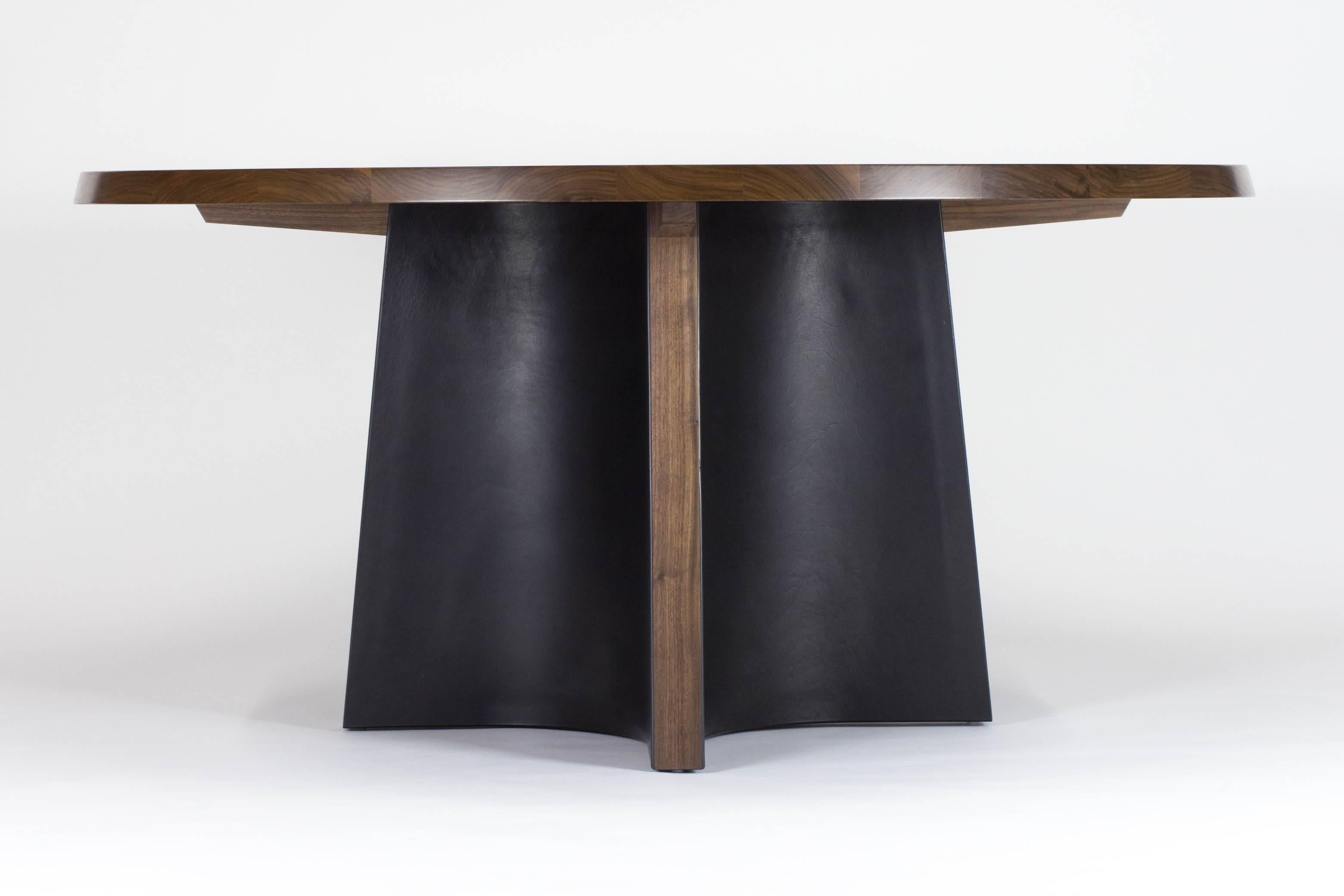 Round table made from solid walnut and heavy saddle leather with a slightly bevelled top edge.