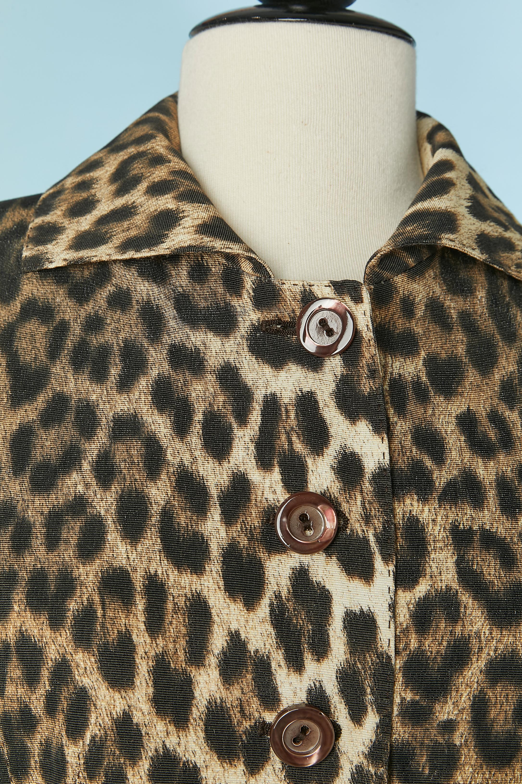 Rockanzug mit Leopardenmuster. Zusammensetzung des Hauptgewebes: 66% Baumwolle, 34% Viskose. Zusammensetzung des Futters: 60% Acetat, 40% Viskose. 
Schulterpolster. Knopf- und Knopflochverschluss in der vorderen Mitte + 1 zusätzlicher Knopf im