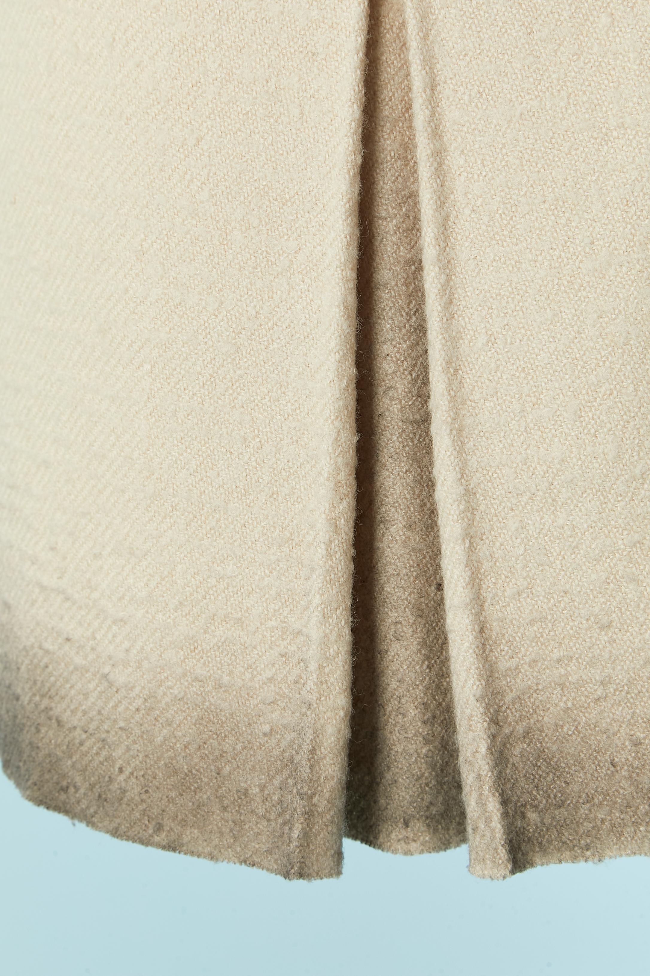 Skirt with box-pleat on the middle front  and beige to grey dégradé. Main fabric composition: 68% wool, 3% polyamide, 29% hemp. Lining: 80% cupro, 17% cotton, 20% polyamide, 1% elastane. 
Zip and hook&eye closure on the left side. Raw edge cut on