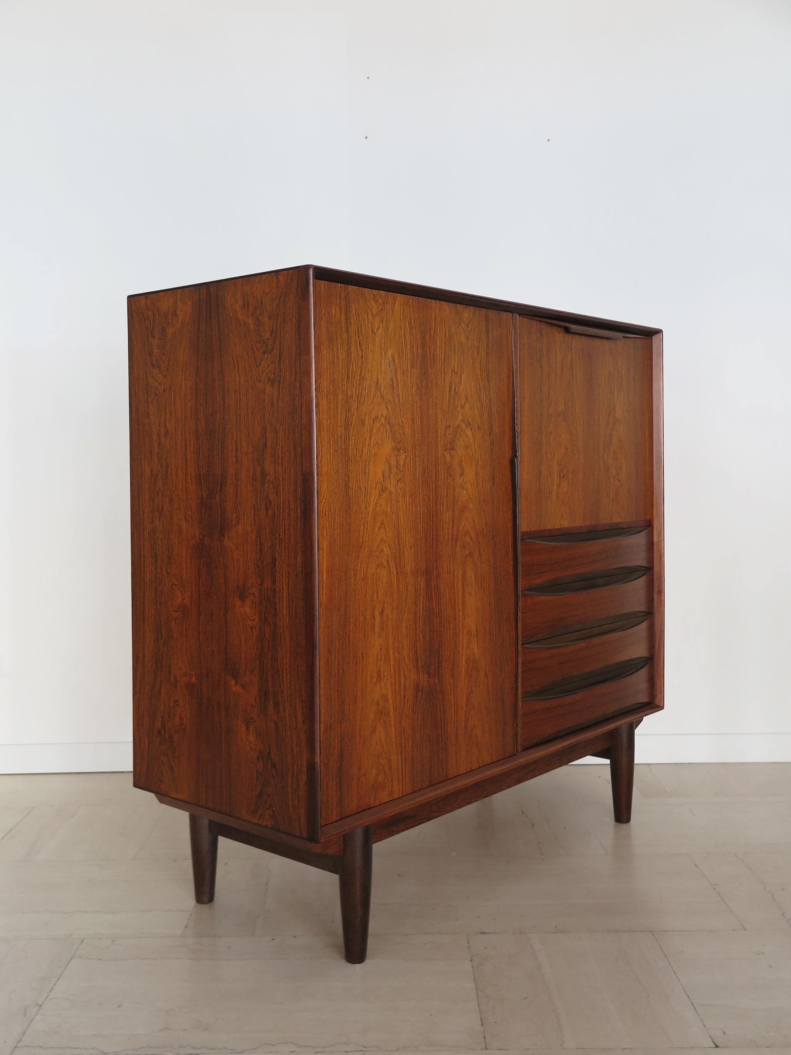Mobile bar in legno di palissandro dal design scandinavo della metà del secolo scorso prodotto da Skobvy Møbelfabrik con due ante, una delle quali si ripiega per diventare un ripiano per bottiglie e bicchieri, Danimarca, anni '60.
Etichetta adesiva