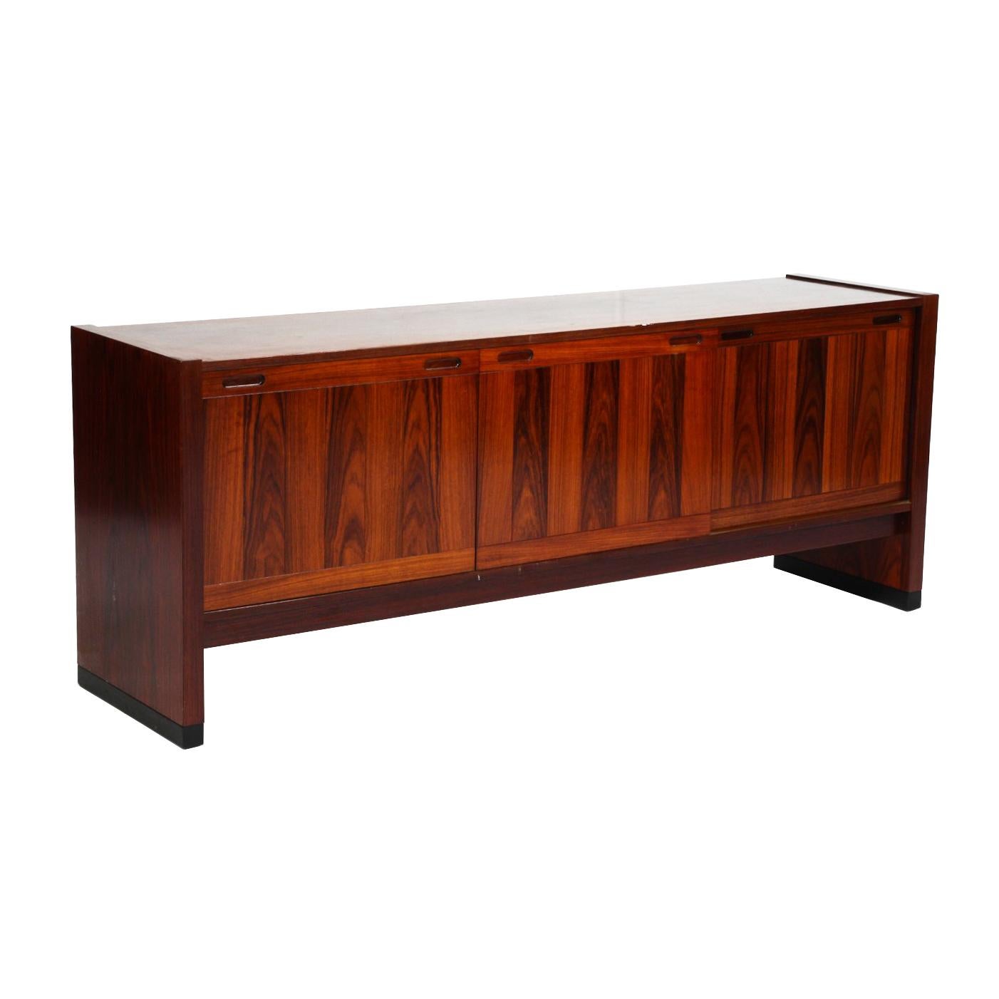 SKovby Rosewood sideboard with three sliding doors. Adjustable shelves and two silverware drawers inside. 

The sideboard is in good condition. However it can be restored professionally to a vintage condition. The piece is restored upon purchase so