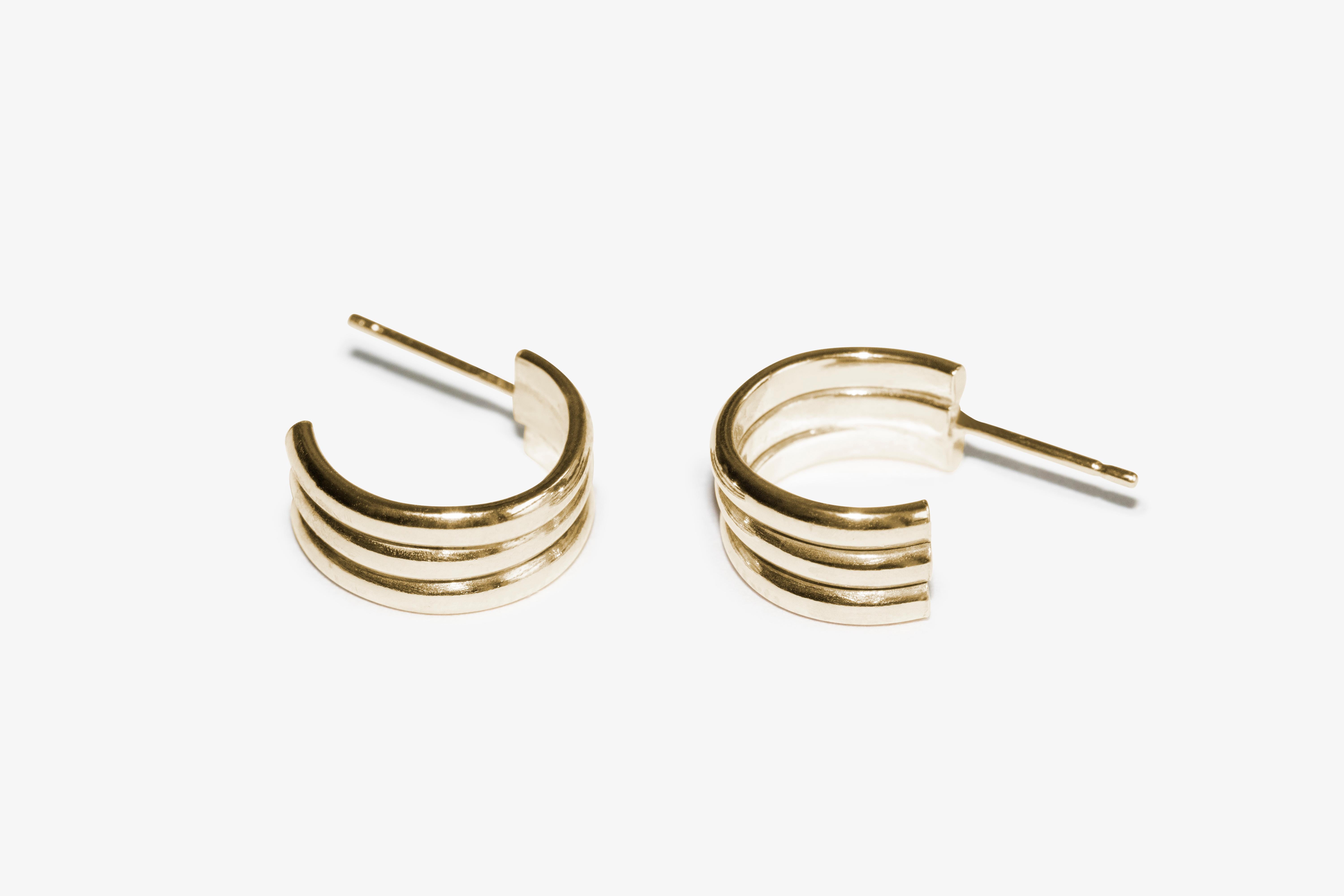 Les boucles d'oreilles Trio, plus volumineuses, sont fabriquées à partir de trois arceaux individuels pour créer une boucle d'oreille à la surface striée et cannelée. Parfaites pour être mélangées à d'autres boucles d'oreilles ou portées seules pour