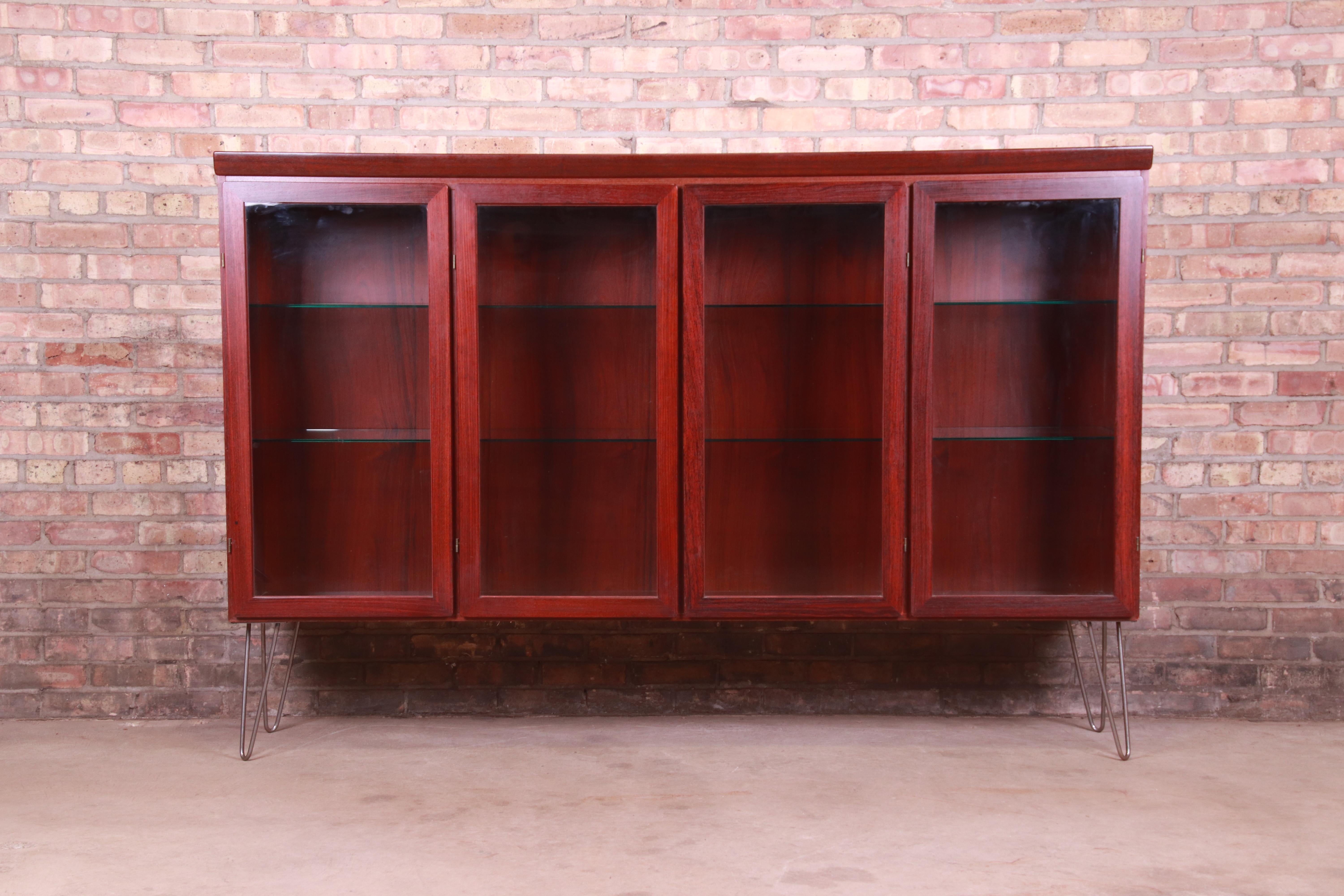 A sleek and stylish mid-century Danish Modern bookcase cabinet

By Skovby Møbelfabrik

Denmark, Circa 1970s

Rosewood, with glass front doors, glass shelves, and metal hairpin legs.

Measures: 77.13