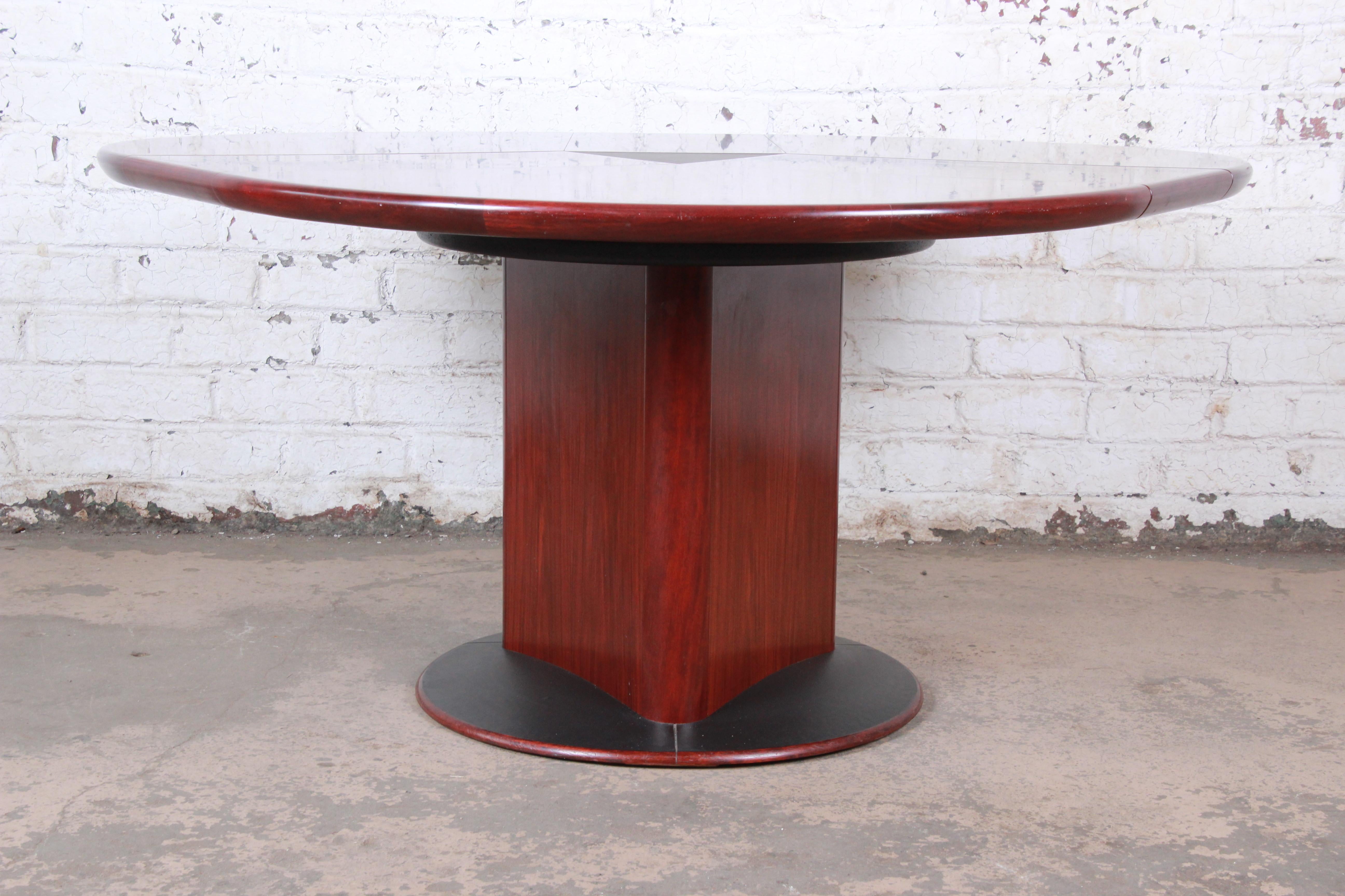 A unique and rare articulating rosewood dining table with three built-in spring loaded leaves

By Skovby Møbelfabrik A/S

Denmark, circa 1970s

Bookmatched rosewood and laminate

Measures: 59.25