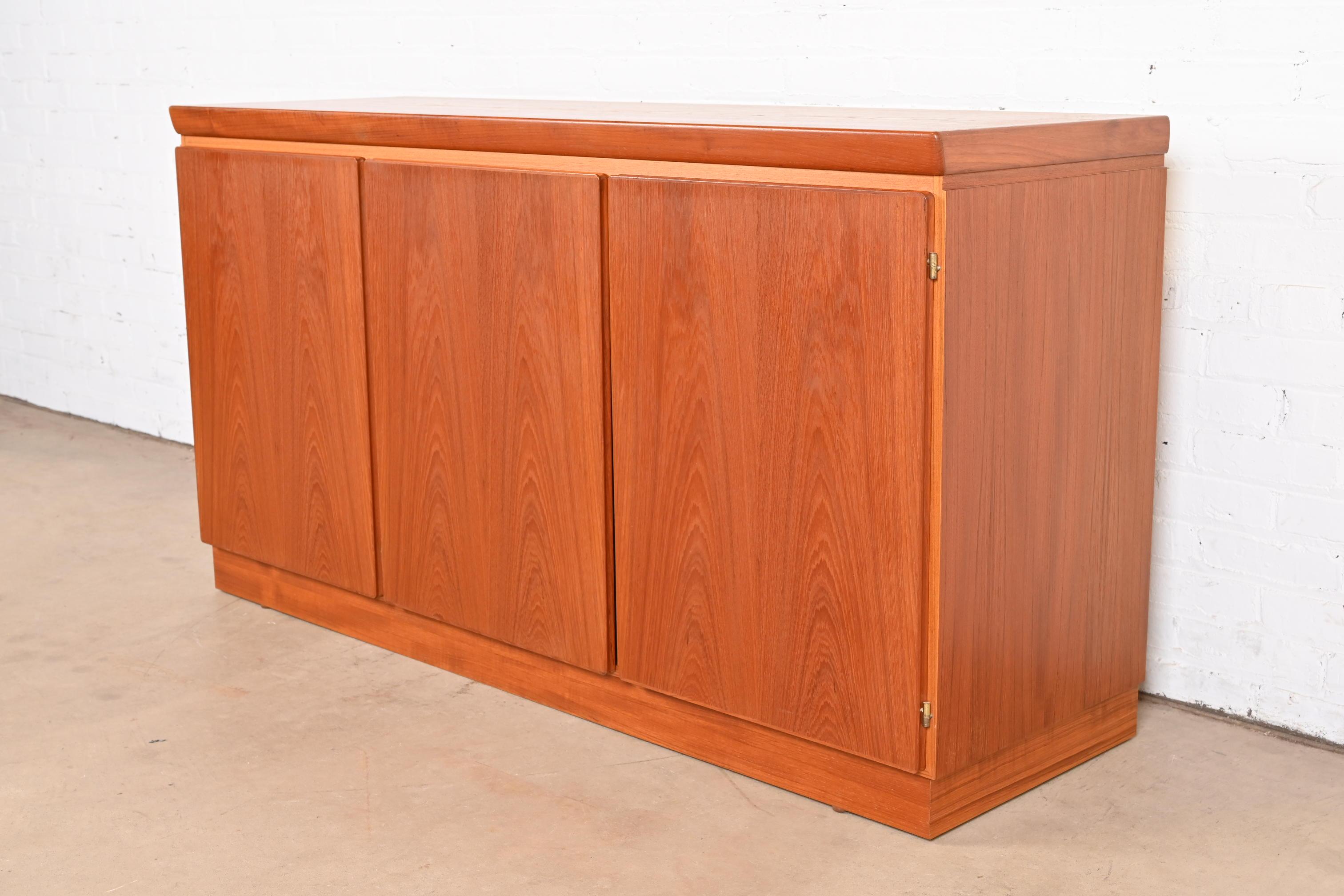 A sleek mid-century Danish Modern sideboard, credenza, or bar cabinet

By Skovby Møbelfabrik

Denmark, Circa 1970s

Gorgeous book-matched teak, with felt-lined drawers.

Measures: 60.75