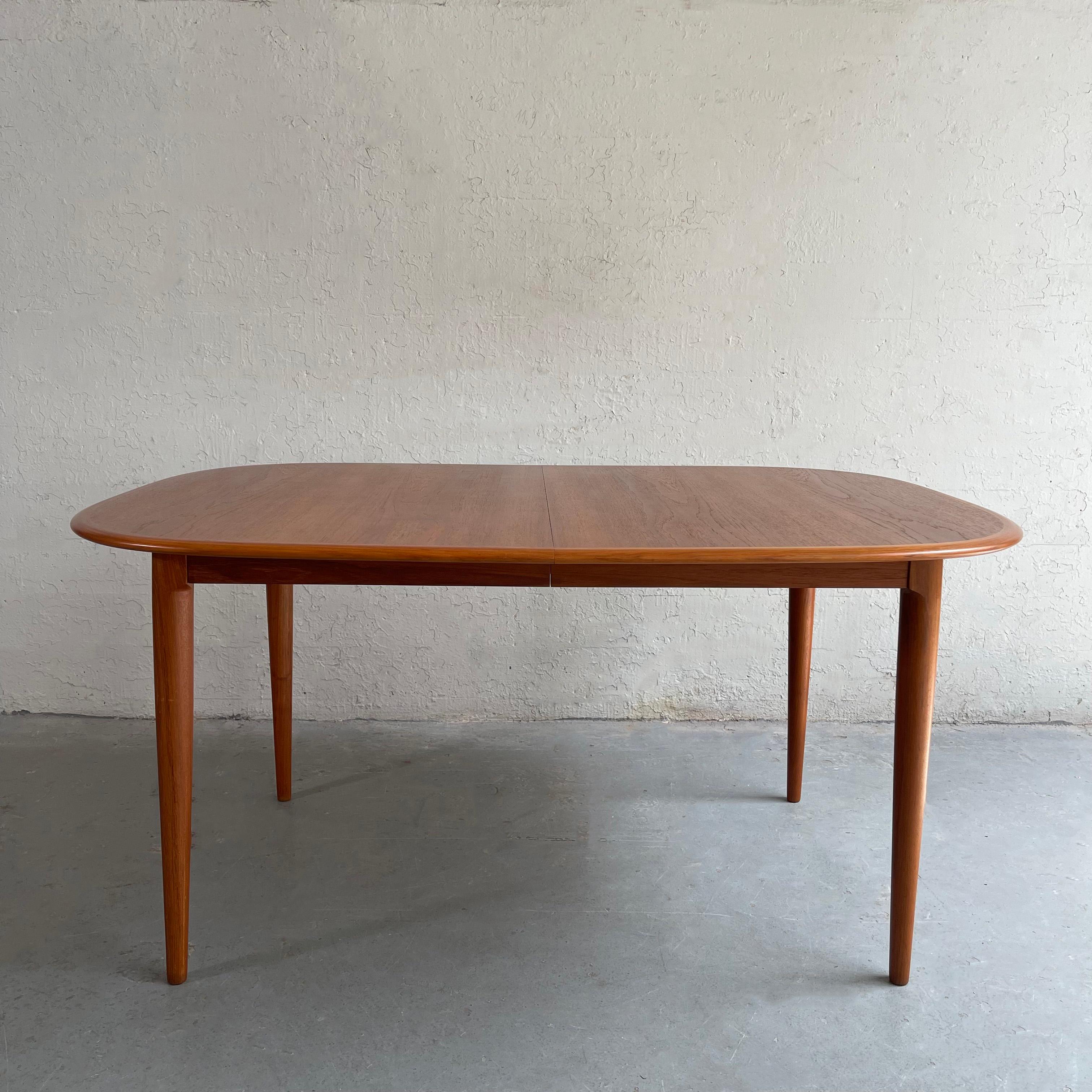Scandinavian modern, teak dining table by Skovmand & Andersen for Moreddi features rounded edges with contrasting trim and elegant tapered legs. The table expands to 78.5 - 98 inches with two 19.5 inch leaves that are stored neatly underneath the