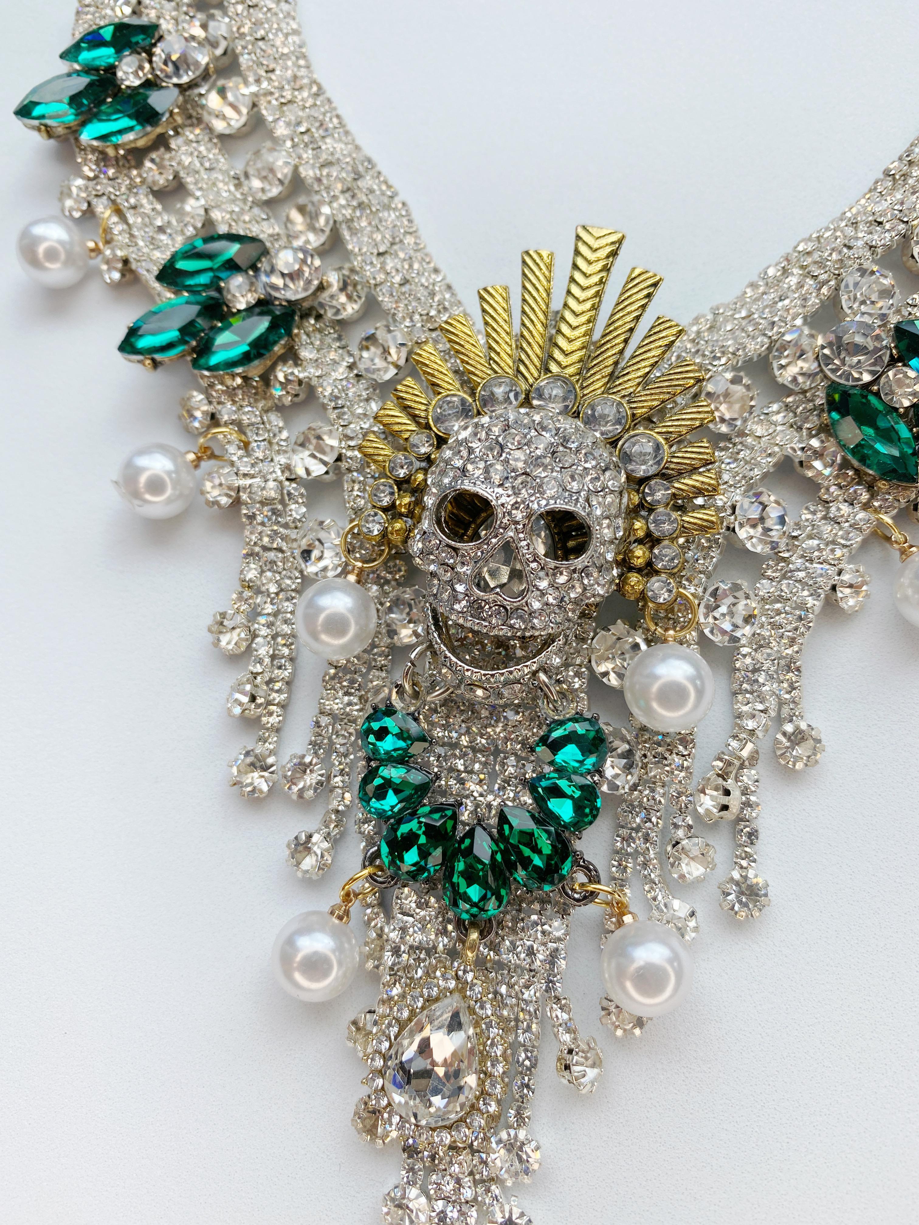 One-of-a-kind Necklace By Sebastian Jaramillo.  This stunning necklace features emerald green and clear crystals with Faux pearls and a center skull. Ajustable length. 