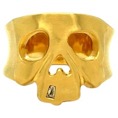 Bague à large anneau ornée d'un motif de crâne et d'un diamant, en or jaune 14 carats.