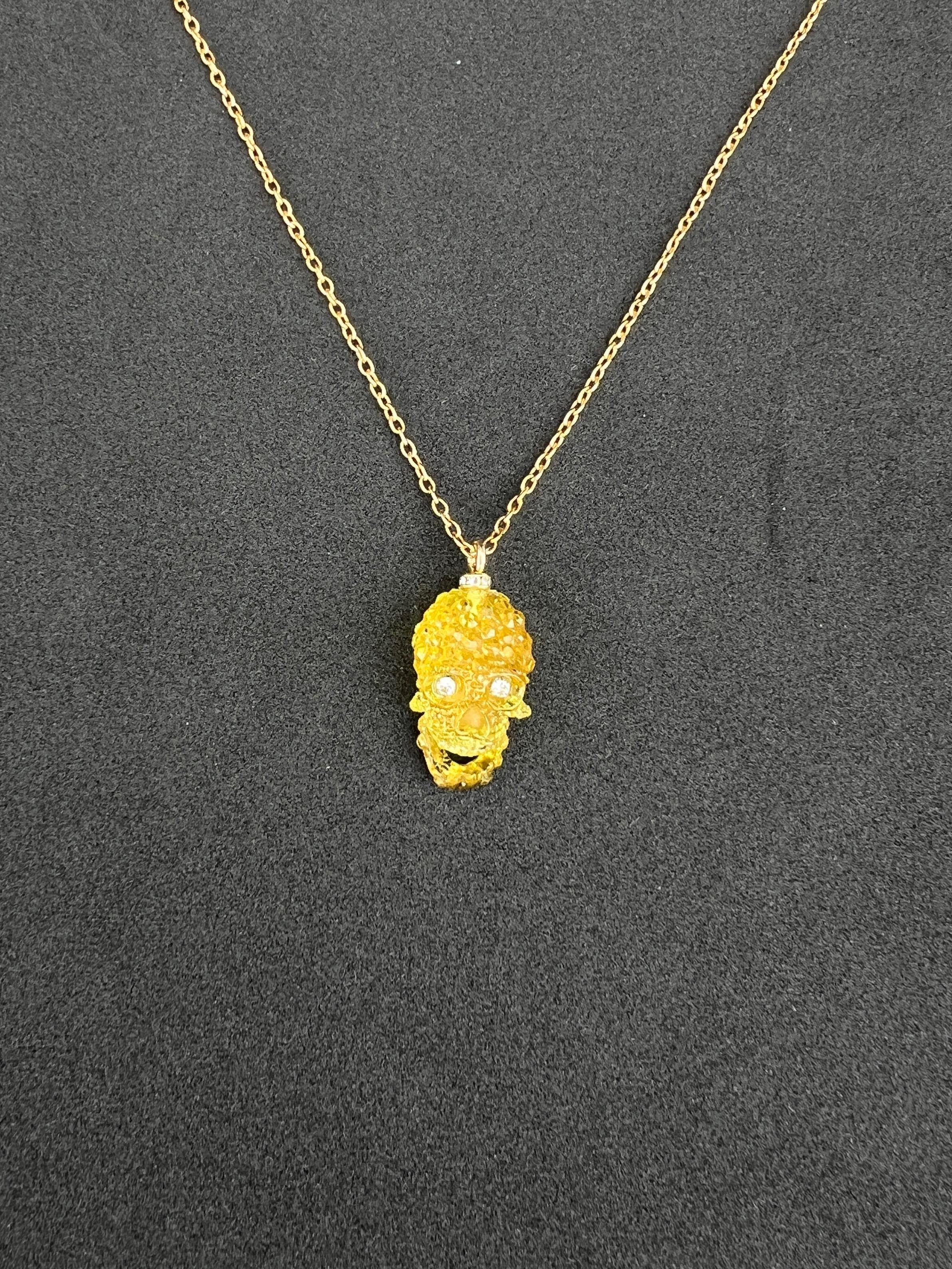 Questa splendida collana con ciondolo è dotata di una catena d'oro che non si appanna e che garantisce una lucentezza e una durata durature. Sospeso alla catena c'è un teschio in resina gialla, intricato e impreziosito da occhi in cristallo