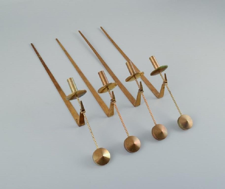 Skultuna, Sweden, four brass candlesticks for wall hanging.
Designer by Pierre Forsell. 
Marked.
In excellent condition. 
Total length 48.5 cm.