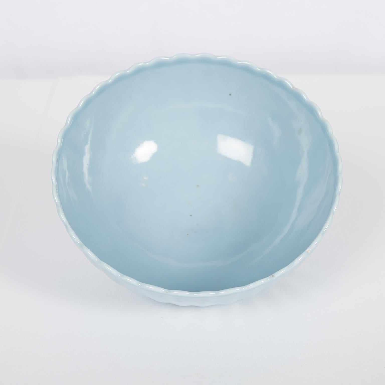 The soft color of this Chinese clair de lune chrysanthemum bowl comes from the glazing technique, which employed a glaze with a small cobalt content to achieve the pale blue hue. The Chinese call this hue of blue, tian lan you, 