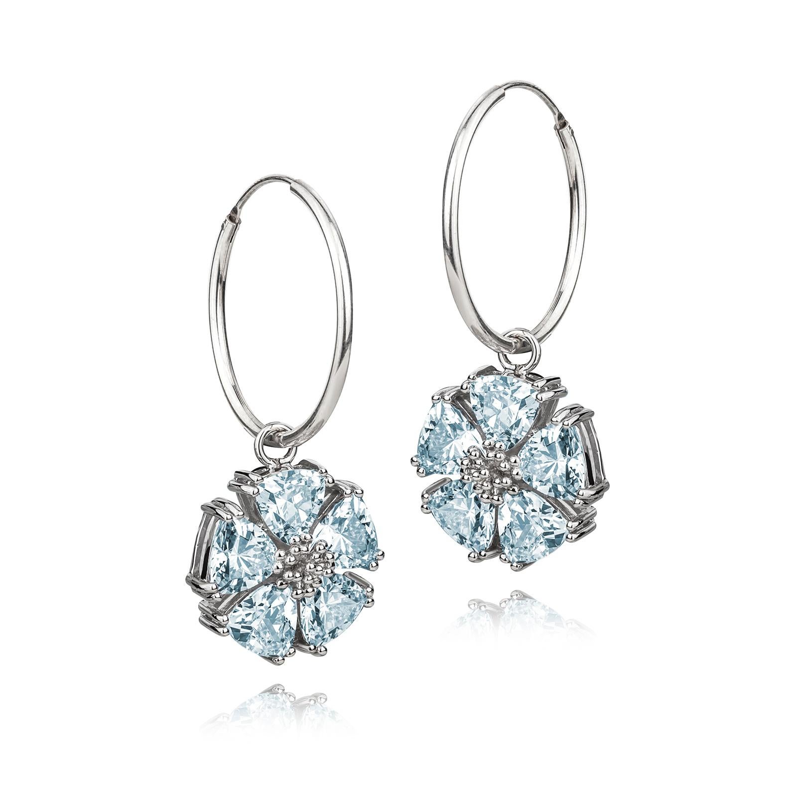 Designed in NYC

.925 Sterling Silver 10 x 7 mm Sky Blue and London Blue Topaz Blossom Stone Dangle Hoops. No matter the season, allow natural beauty to surround you wherever you go. Blossom stone dangle hoops: 

	Sterling silver 
	High-polish