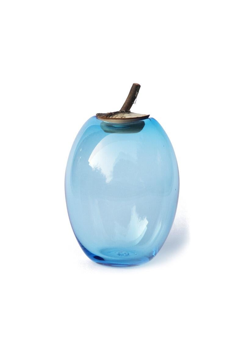 Sky Blue Branch Bowl, Pia Wüstenberg
Dimensions: D 16-18 x H 29
Materials: glass, wood
Available in other colors.

A playful jar, with a lid made from a branch stub following the curvature of the glass. Branch Bowls are blown without a mould: