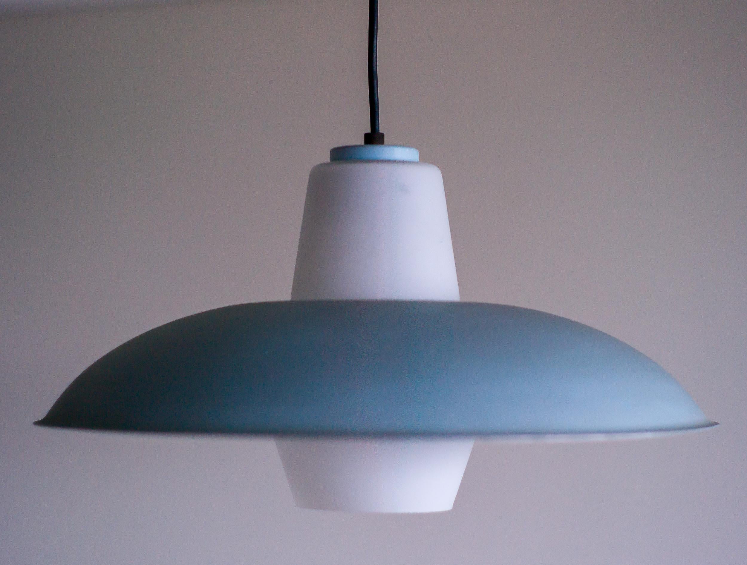 Wonderful Mid-Century Modern Dutch frosted glass pendant with light blue and dark blue enameled aluminum shades designed by Louis Kalff for Philips, The Netherlands, circa 1956.

Louis Kalff (1897-1976) was a visionary Dutch designer known for his