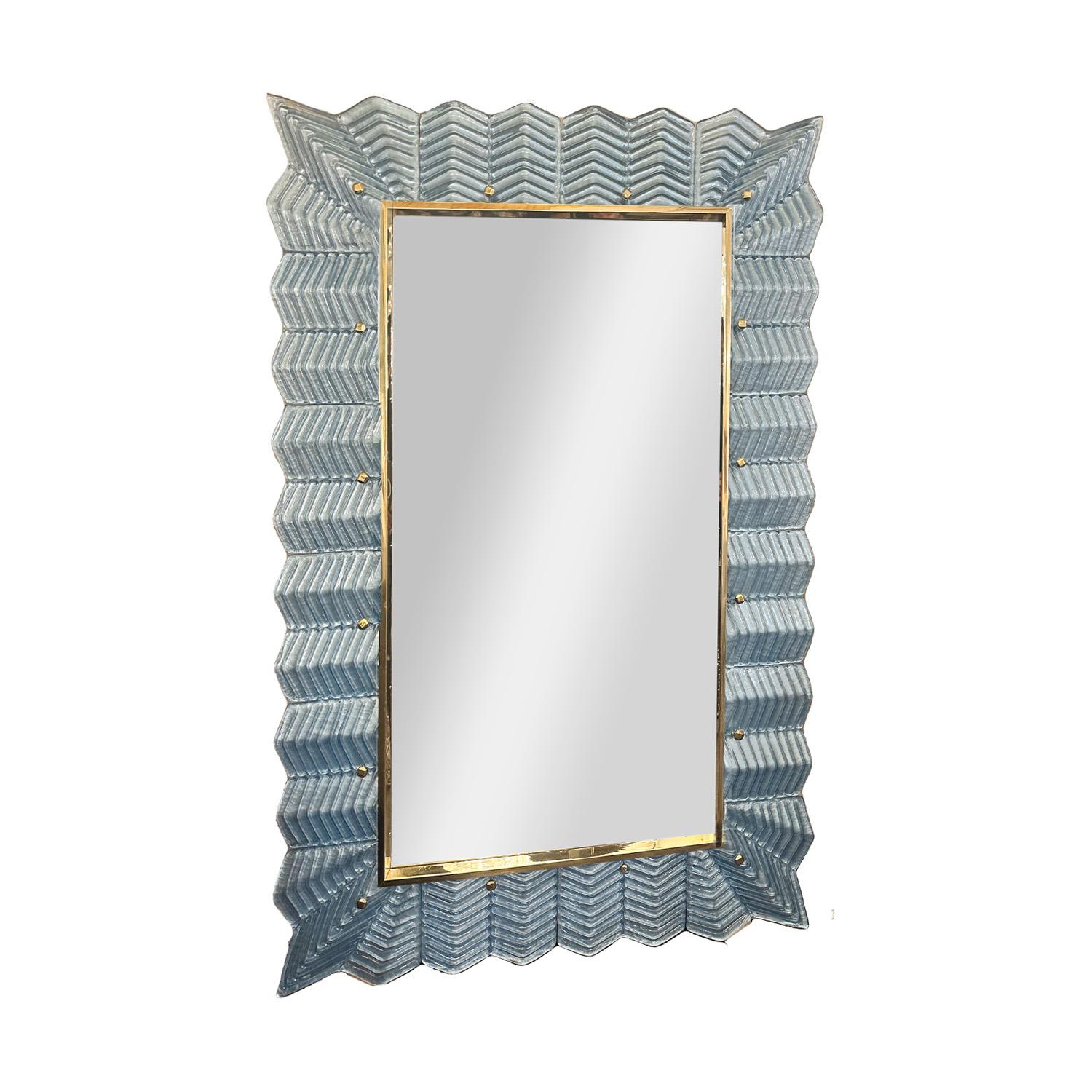 Donnez à votre intérieur une touche de glamour. Des carreaux de verre bleu de Murano à motif de chevrons, soutenus par des feuilles d'argent, forment un cadre élégant autour d'un miroir garni de laiton poli. Italie.

 Ce miroir est actuellement