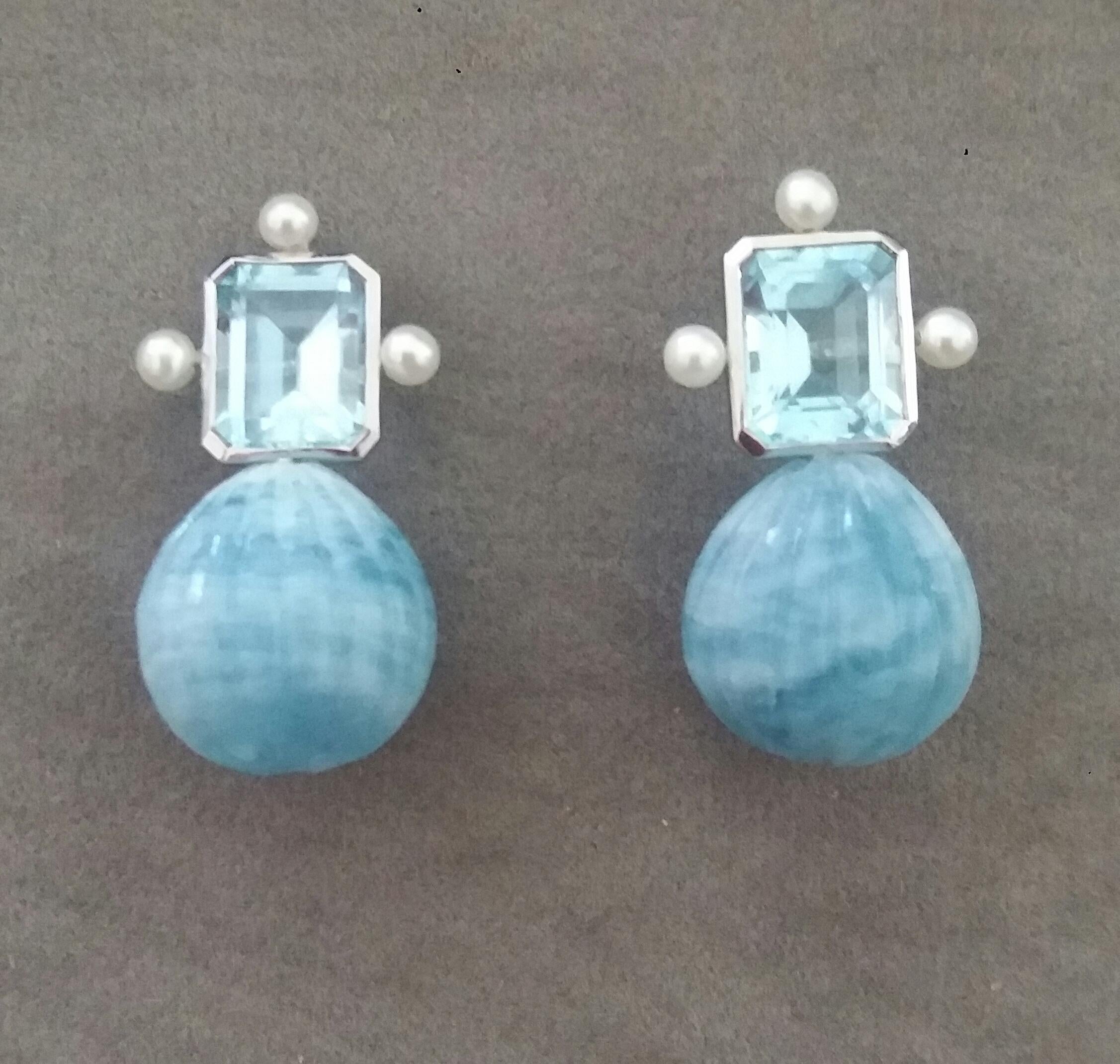 These elegant and handmade earrings have 2 Octagon Faceted Sky Blue Topaz measuring 9 x 11 mm set in a 14 Kt white gold bezel with 3 small round pearls of 4mm on 3 sides at the top to which are suspended 2 Engraved Natural Aquamarine  Round Drops