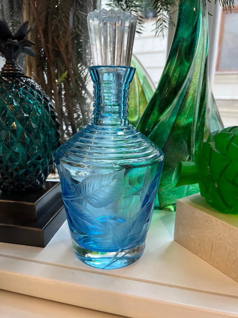 Die mundgeblasene und handgeschliffene Whiskeykaraffe aus himmelblauem Glas ist von der Natur mit ihren frühlingshaften Efeublättern inspiriert und wird mit einem klaren, handgeschliffenen Verschluss geliefert.
Das Fy-shan Glass Studio hat es sich
