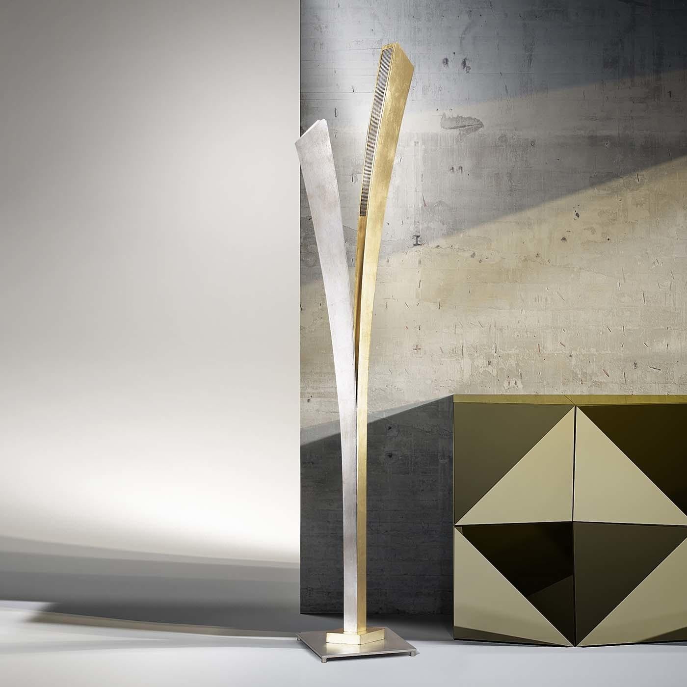 This handmade striking three-light floor lamp features a simple design adorned with two leaf-like metal elements, one with a gold leaf finish and another with a silver leaf finish. The effect is elegant and Minimalist at the same time.

   