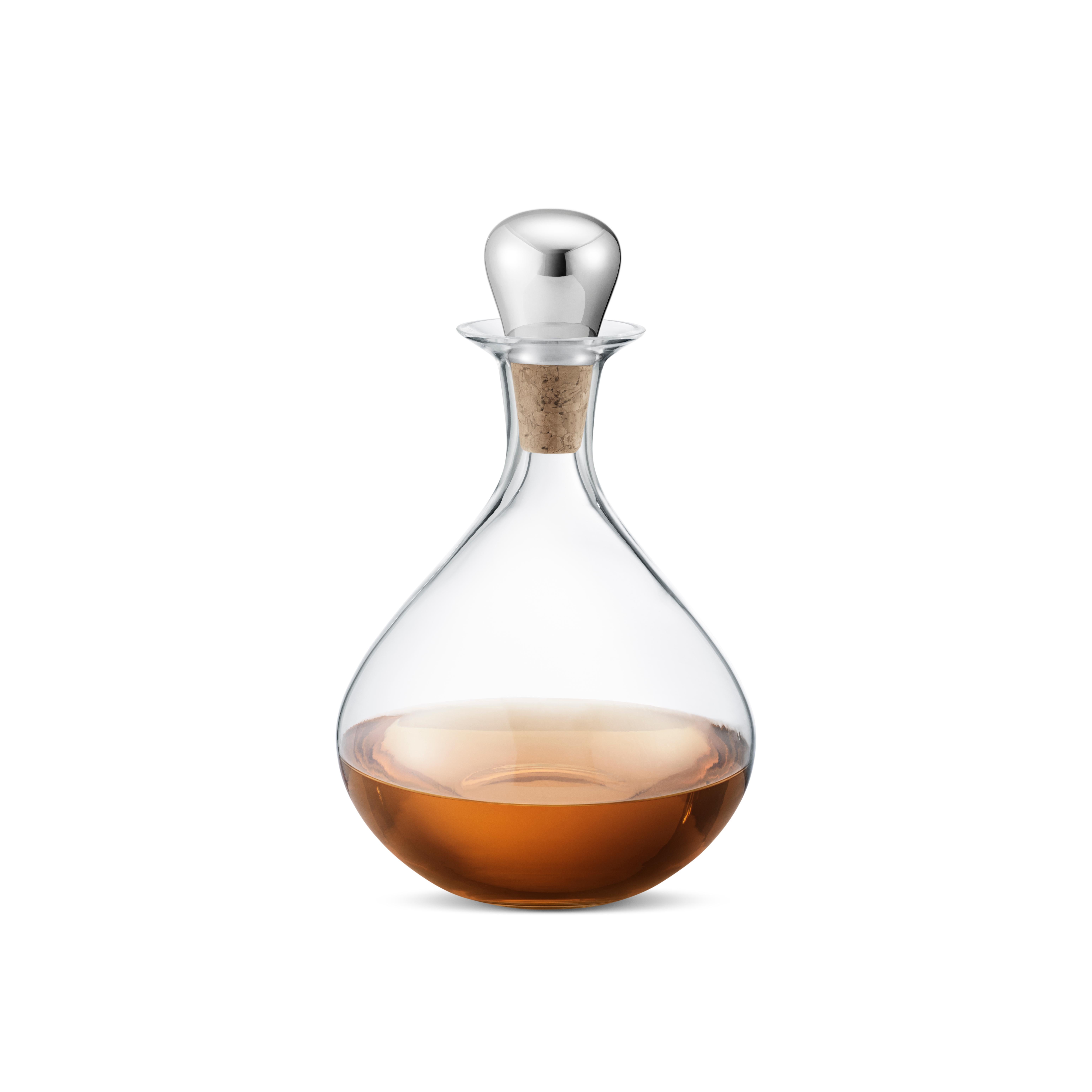 Part of the enjoyment of wine or spirits is beyond just taste: the beautiful color and aroma also play an important part. This beautiful crystal decanter with its ergonomic and sculptural stainless steel and cork stopper is a striking addition to