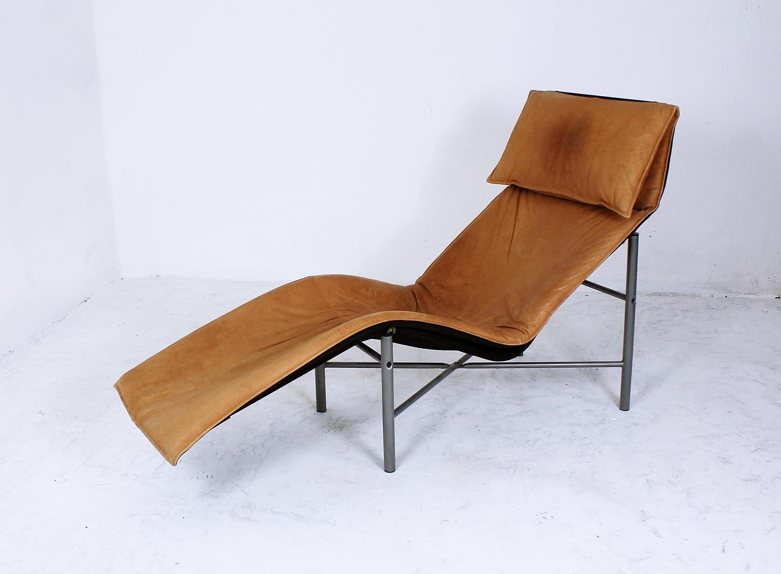 The Skye lounger was designed by Swedish interior designer Tord Björklund for Ikea. This chair features a patinated light brown leather cushion on a black canvas supported by a silver painted tubular metal base.