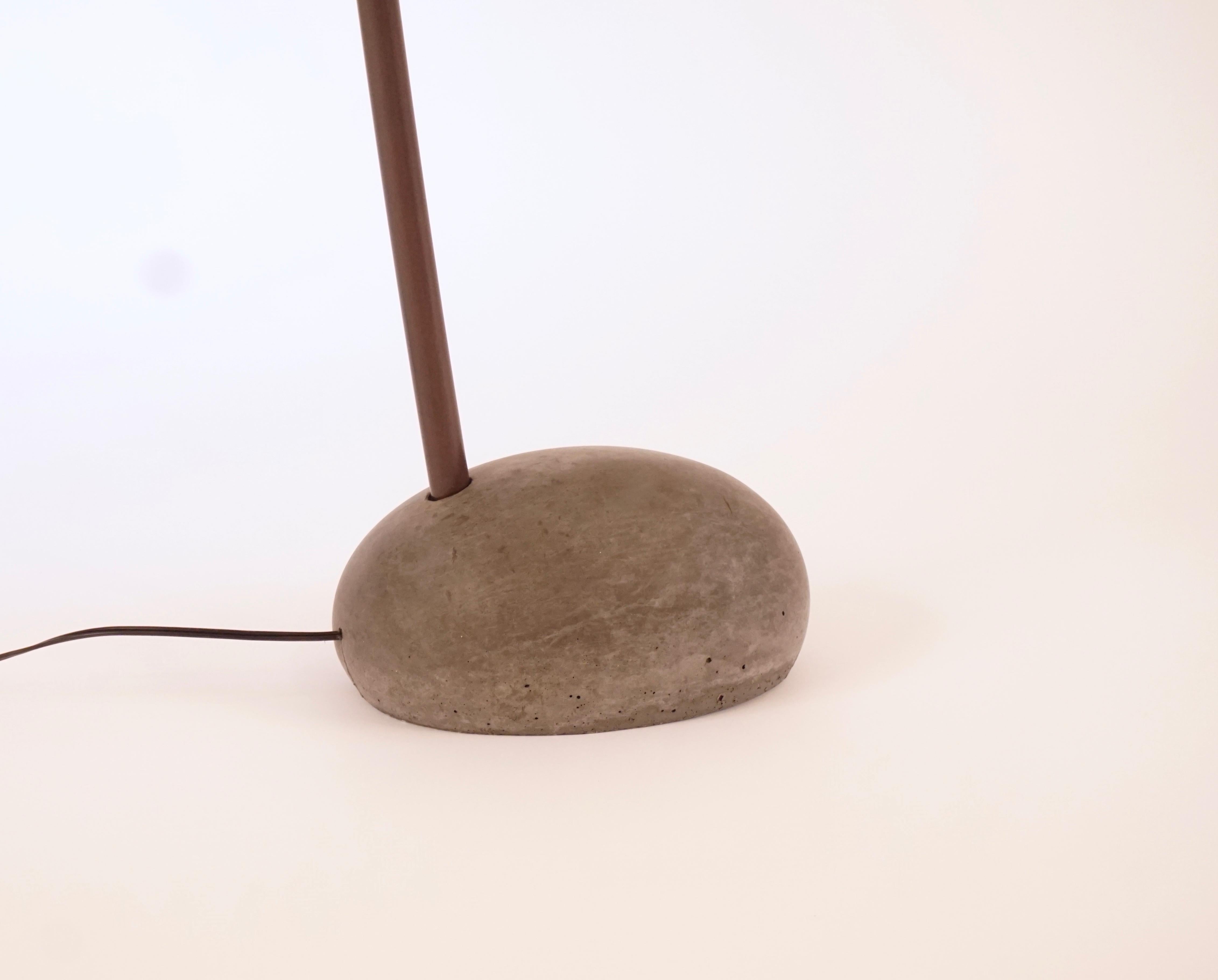 This is the large version of the sky floor lamp. The darkened colored cement base was made with forms taken from actual stones from the Isle of Skye. The arm is solid bronze with an acid darkened patina, the shade is a hand spun aluminum shade that