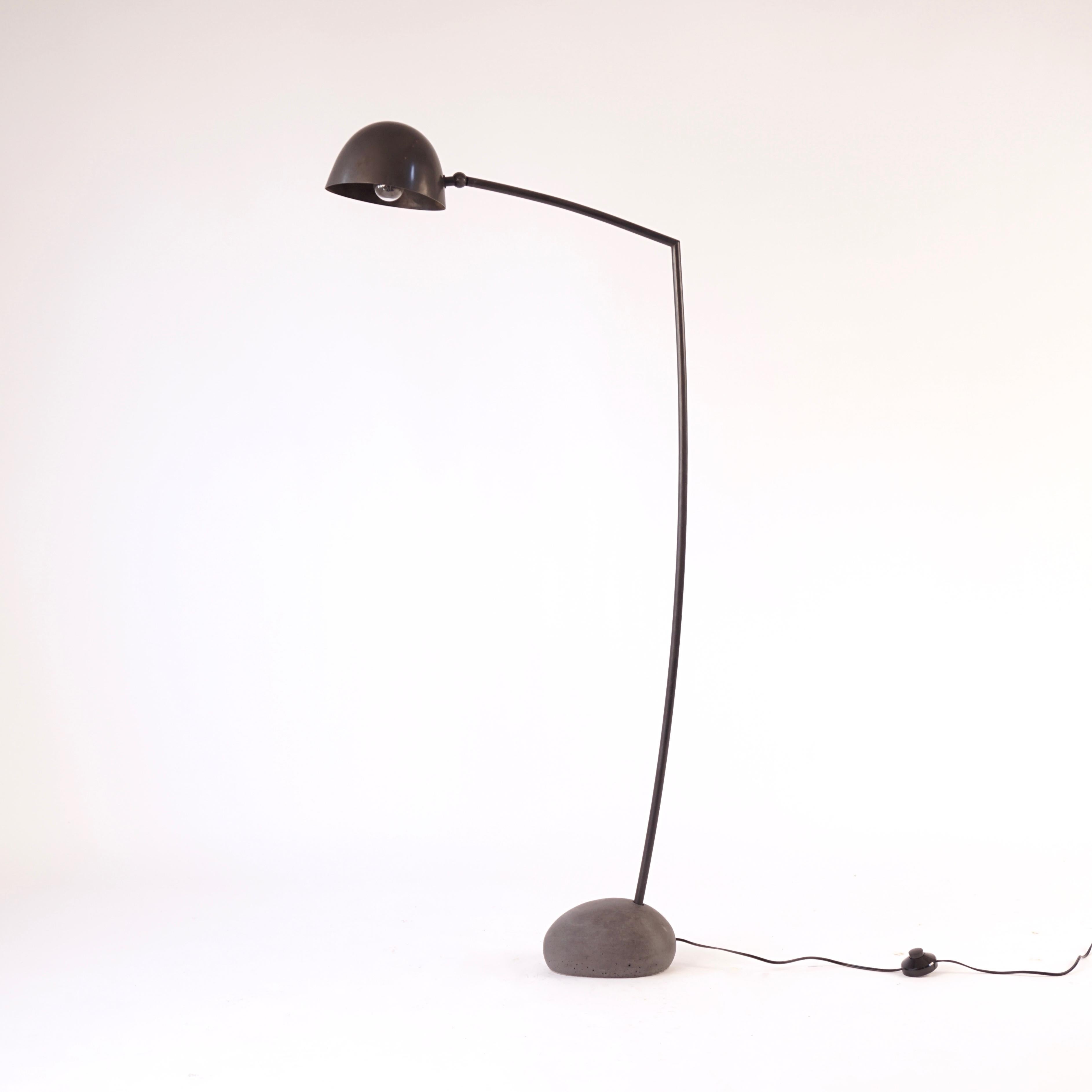 This is the medium version of the Skye floor lamp. This dark colored cement base was made with forms taken from actual stones from the Isle of Skye. The hand spun shade and arm are solid bronze with an acid darkened patina. The shade articulates