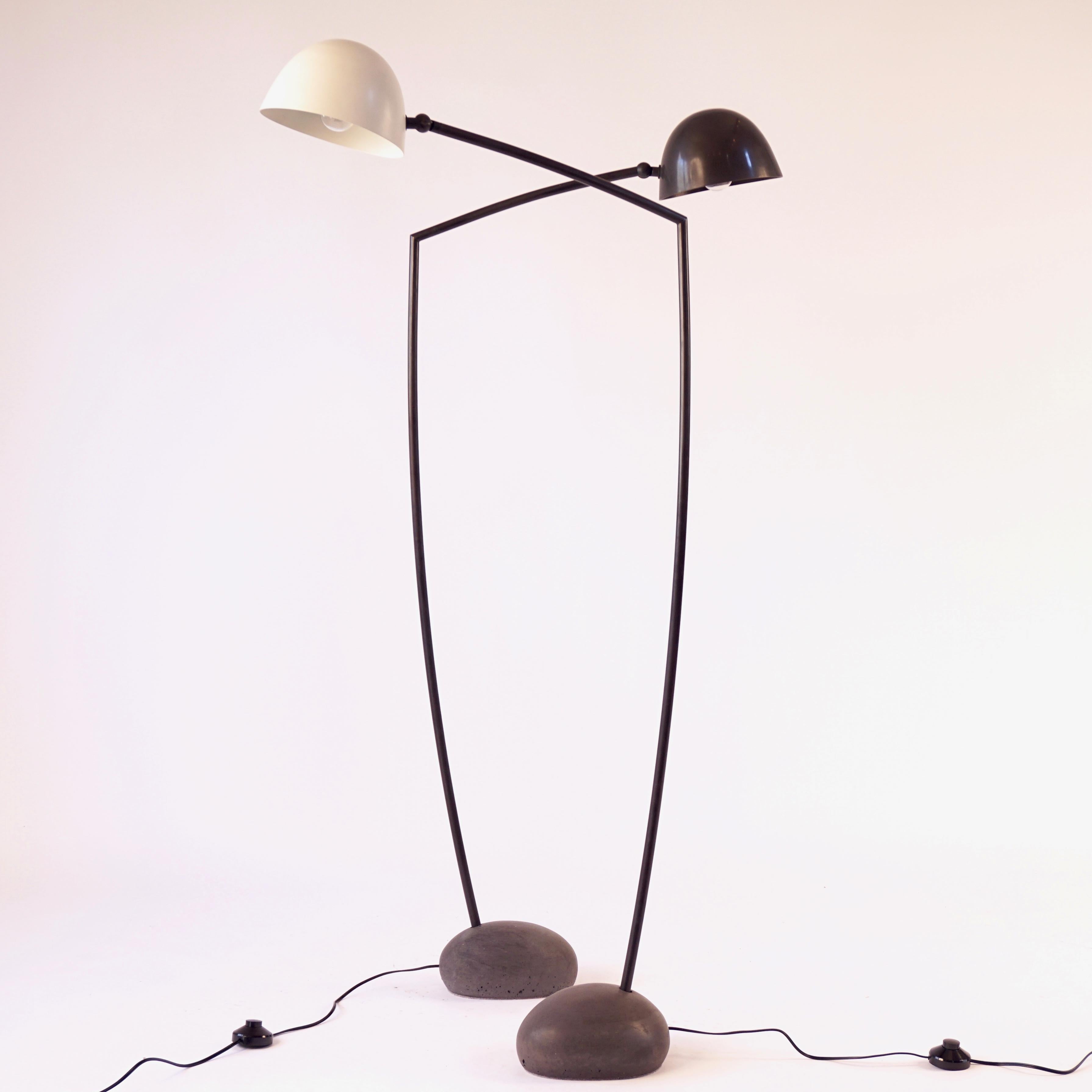 This is the medium version of the Skye floor lamp. This dark colored cement base was made with forms taken from actual stones from the Isle of Skye. The hand spun shade is powder coated white and the arm is solid bronze with an acid darkened patina.