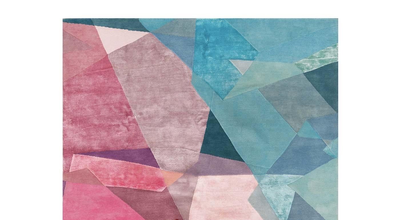Dieser Teppich ist Teil der Design-Kollektion und wird in Nepal handgeknüpft. Es besteht aus einer Reihe von blauen und rosafarbenen Prismen, die sich vor einem dunklen Hintergrund abheben und ein Design mit starker visueller Wirkung schaffen. Es