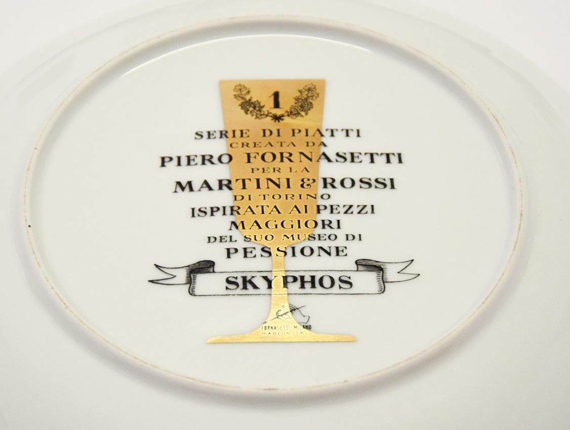 Skyphos ist ein eleganter Porzellanteller mit Siebdruck, der in den 1960er Jahren von Piero Fornasetti für Martini & Rossi entworfen wurde.

In ausgezeichnetem Zustand: so gut wie neu. 

Schwarz-weißer Wandteller aus Fornasetti-Keramik, fein
