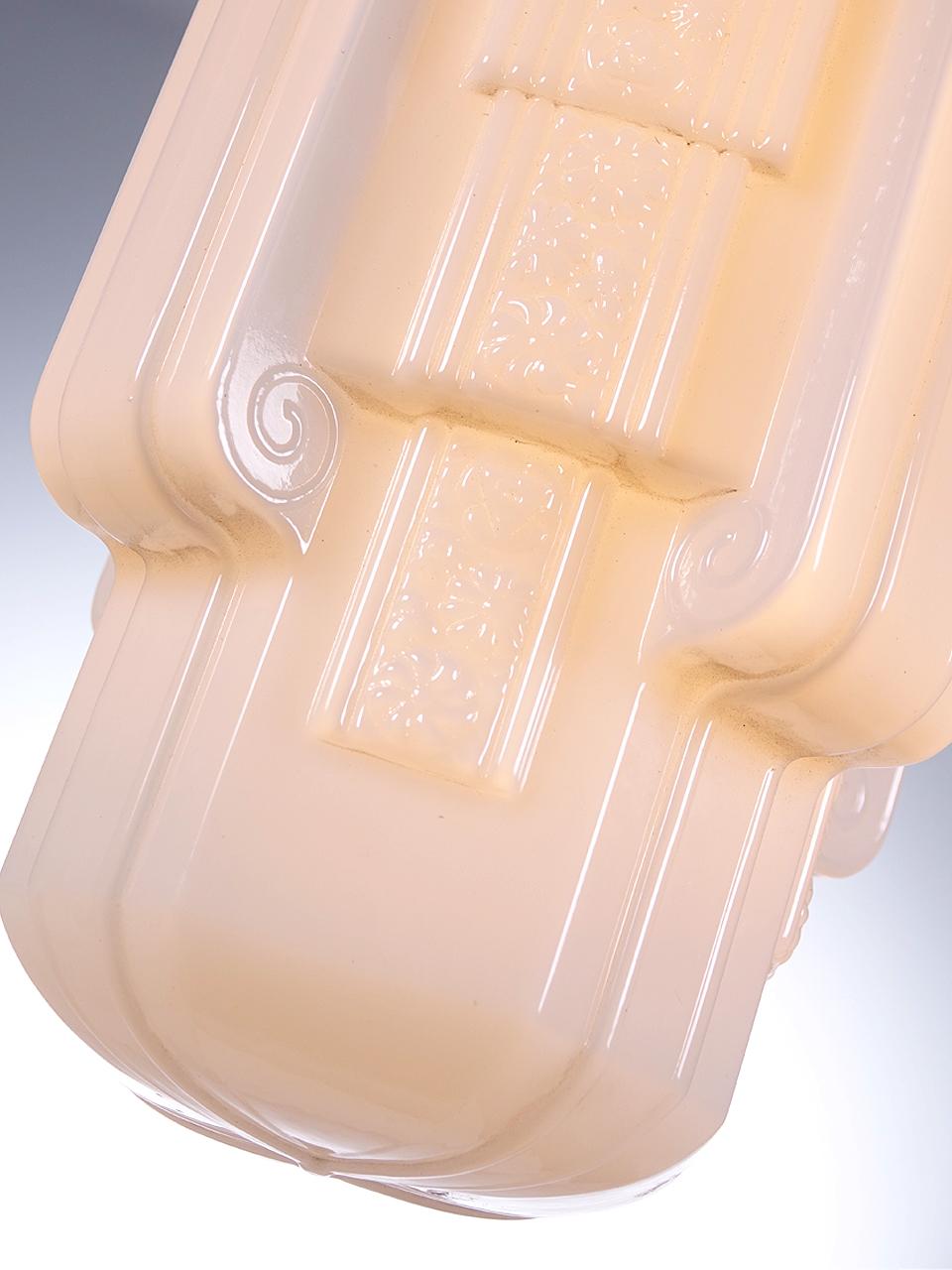 This is a beautiful large elongated skyscraper lamp. The cast glass shade is deeply detailed and is milk glass.
