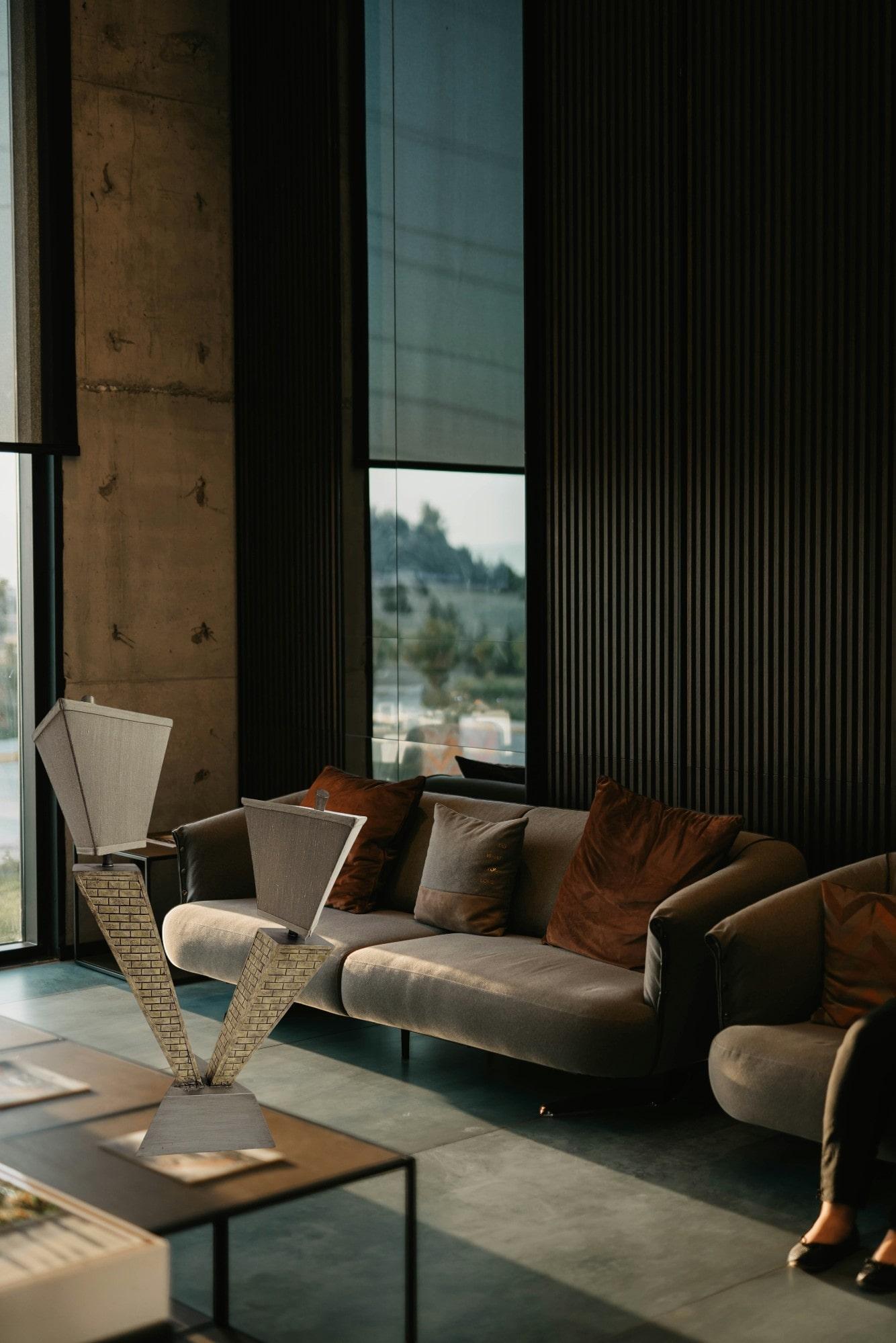 This table lamp captures the bold lines and architectural drama reminiscent of classic skyscrapers. The stepped body and geometric textured silk shades create a striking silhouette. This lamp brings a unique blend of vintage and modern aesthetics.