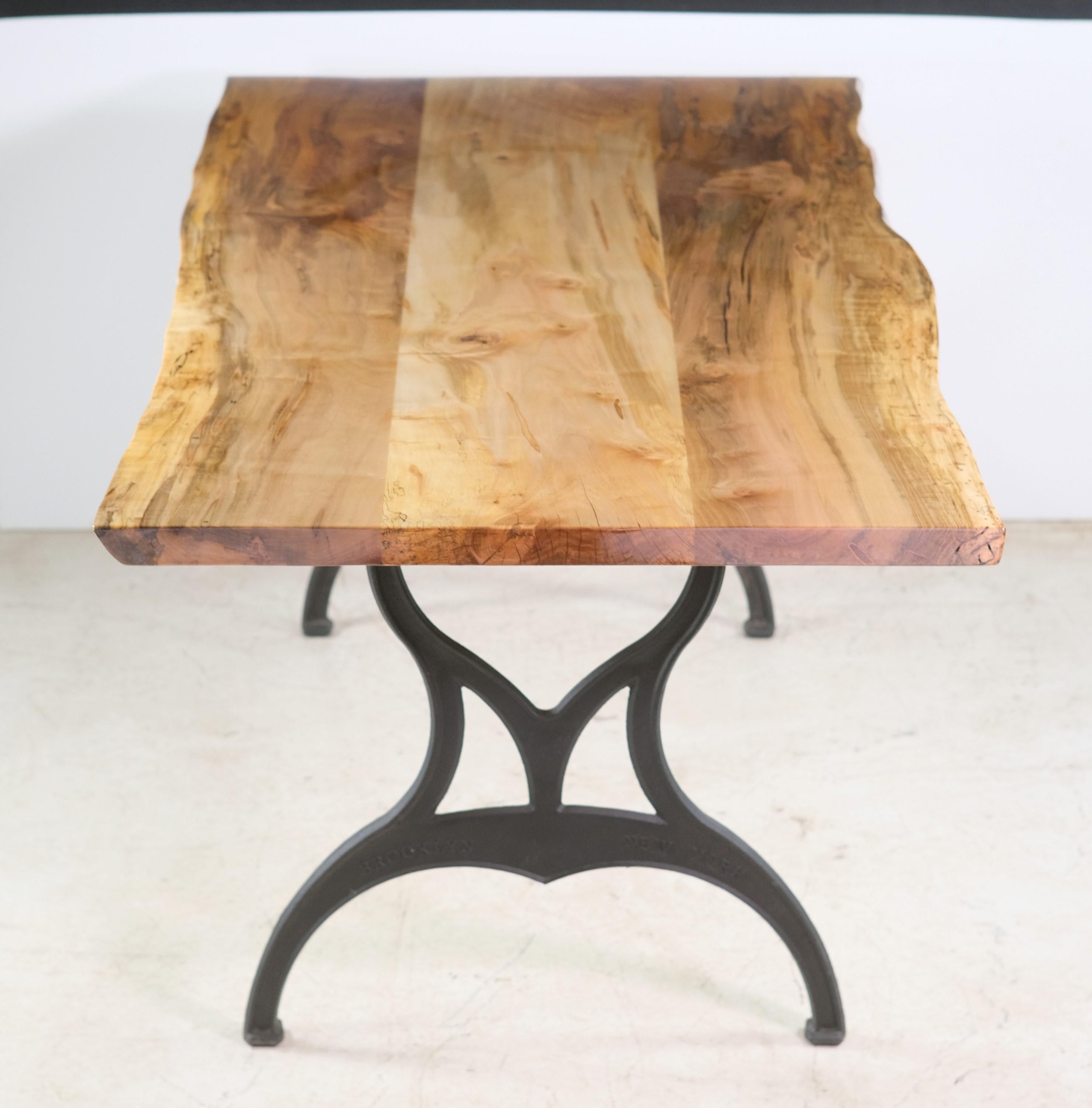 One-of-a-kind dining table made with a one-piece slab of live edge maple paired with black industrial cast iron Brooklyn machine legs. There is some finish hazing on the ends. This table is ready to ship. This can be seen at our 333 West 52nd St