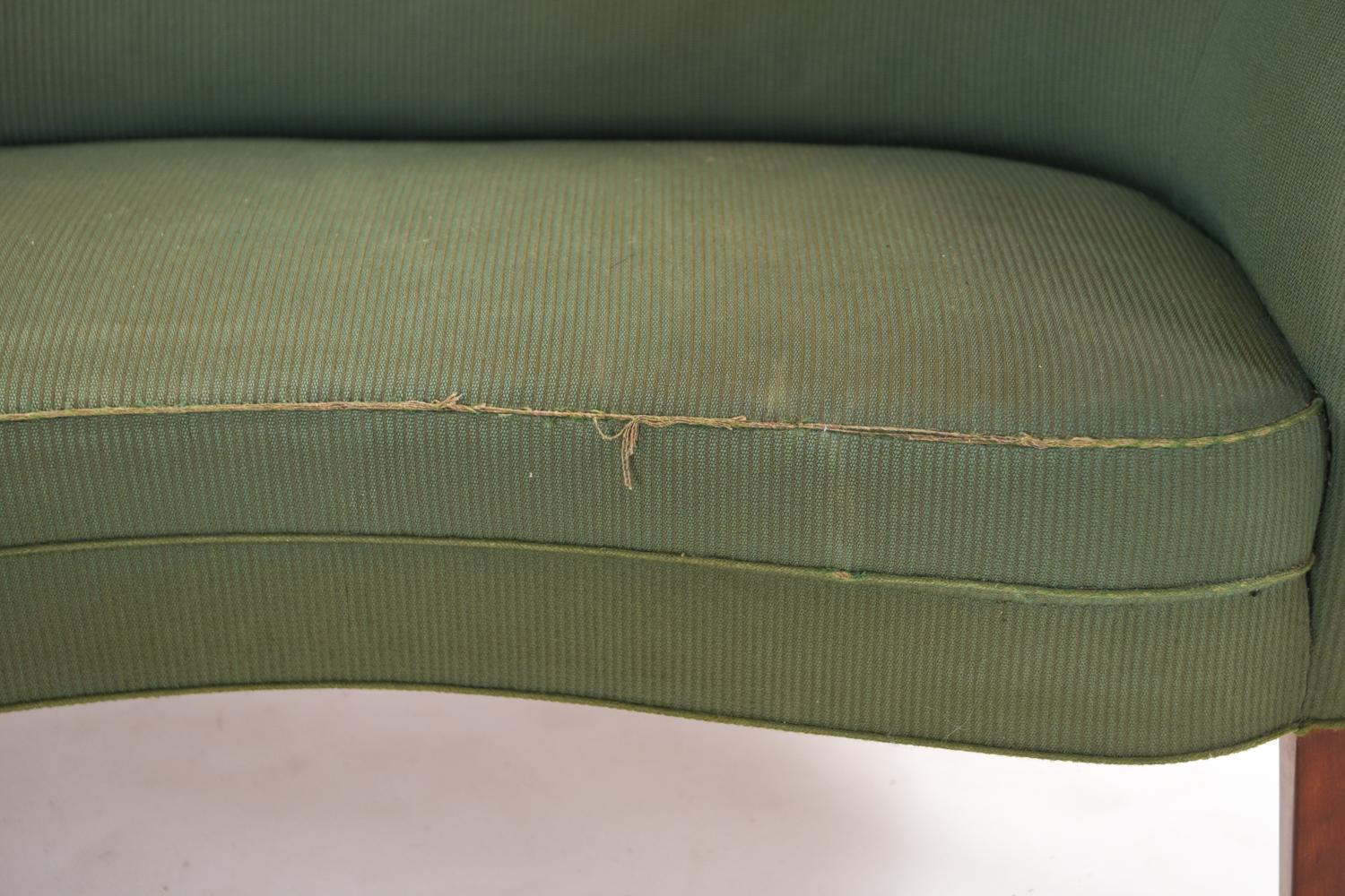 An unusual model 185 Danish midcentury sofa by Slagelse Mobelvaerk. This modern sofa features a design composed of curved lines and a tufted back. In original green upholstery, a blank slate which could be updated to suit one's personal style.