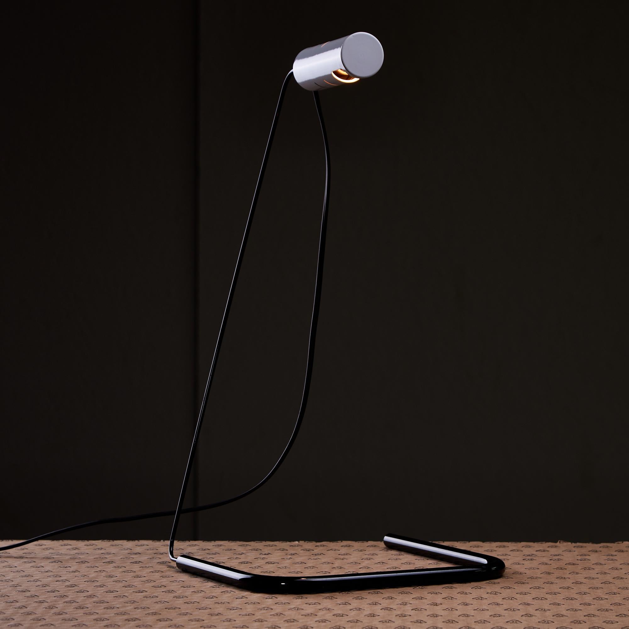 The Slalom desk lamp was designed by Vico Magistretti for Oluce in the 1980s. It's an iconic piece of Italian lighting design that showcases the combination of functionality and aesthetic appeal. The lamp features a distinctive, elegant form