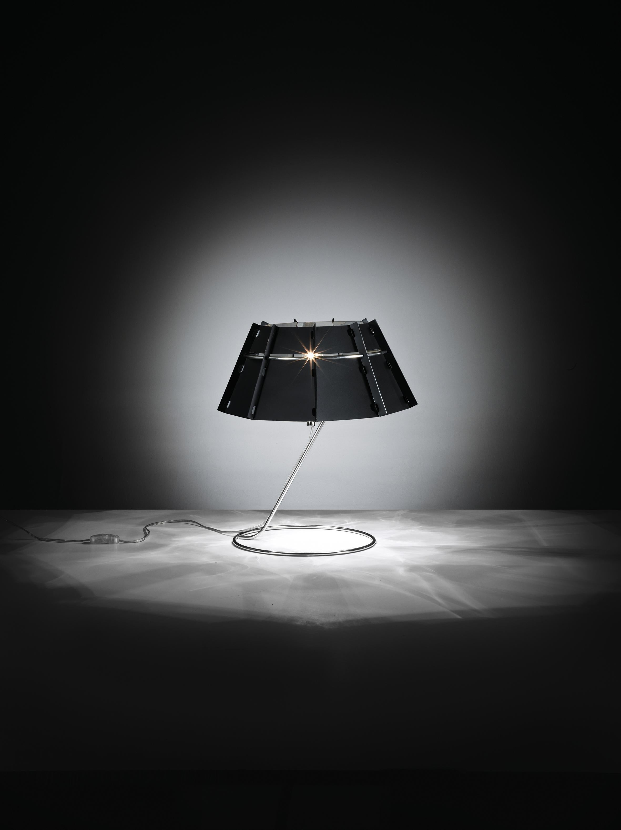 A modern design rich in dynamic character. The mirrored inside is enveloped by a black layer, creating particularly elegant refractions of light that extend above and below the lamp. Chapeau is available in floor, suspension, and table versions, and